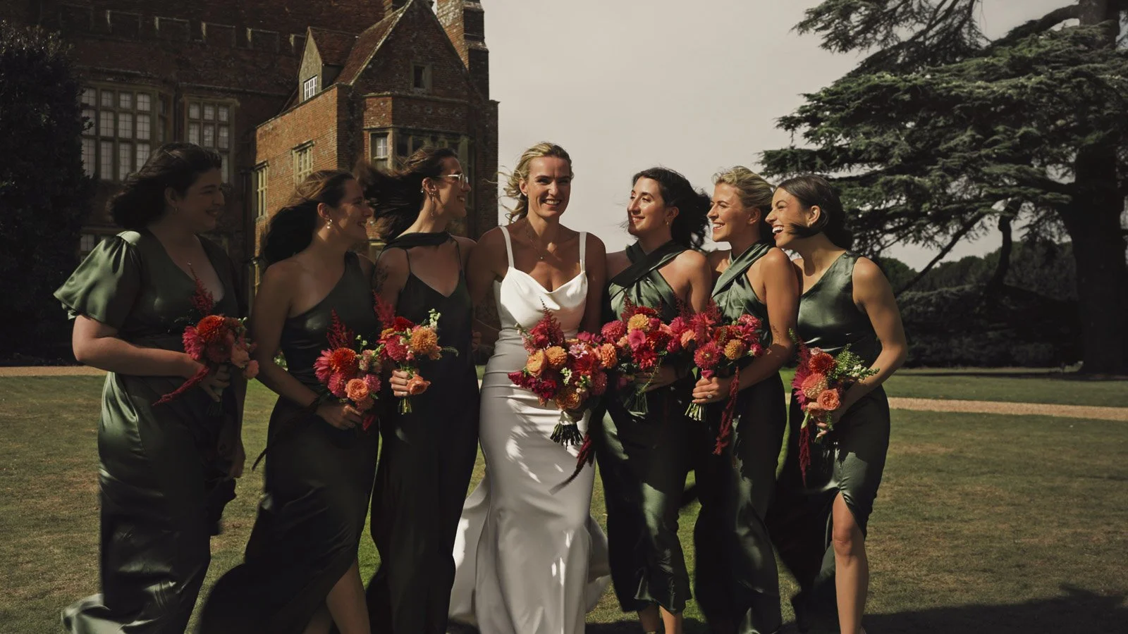 Editorial-style wedding photography from a colourful riverside celebration with bold florals and a marquee reception.