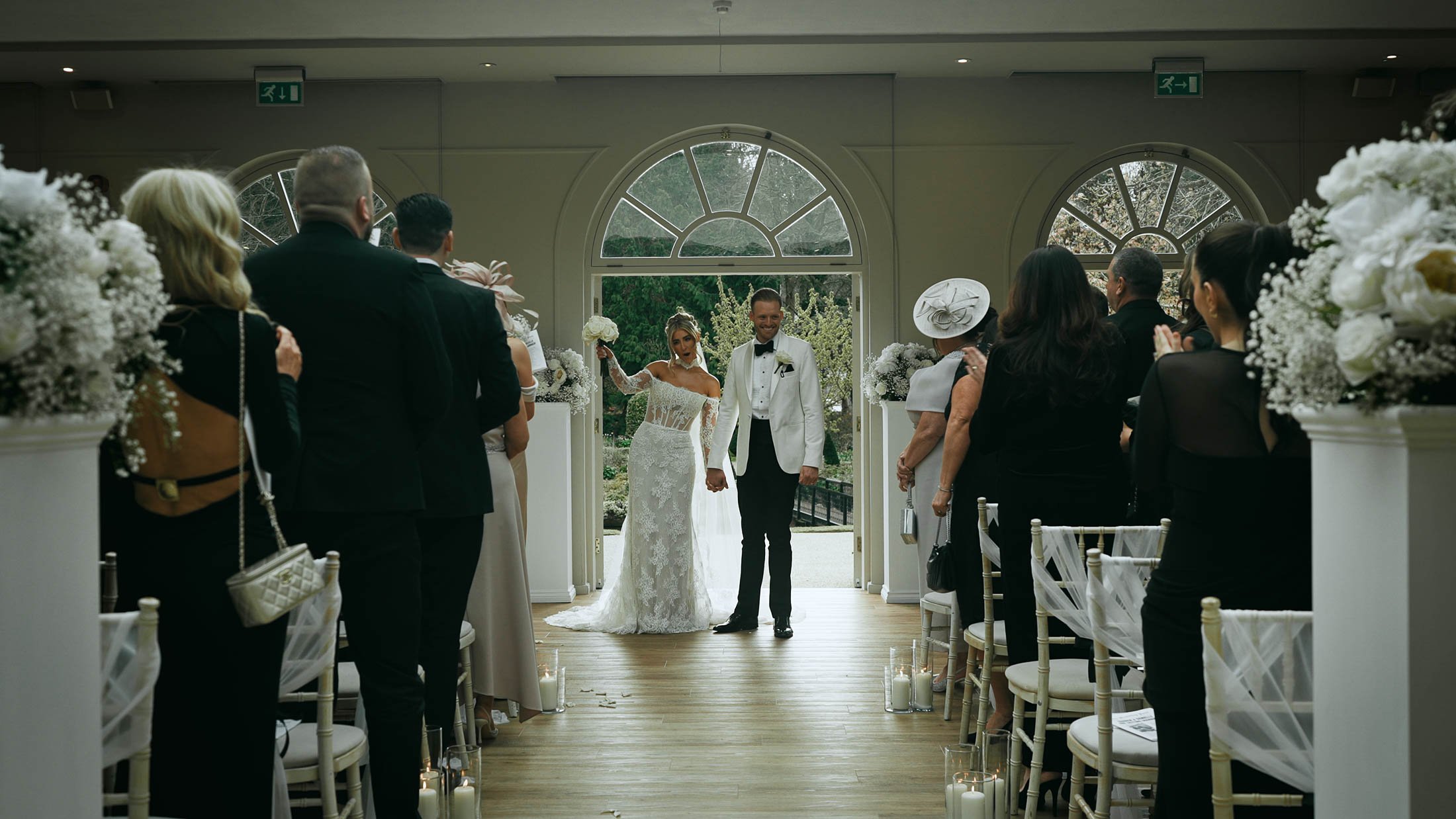 A couple celebrate during their indoor wedding ceremony, a happy moment during their storytelling wedding film.