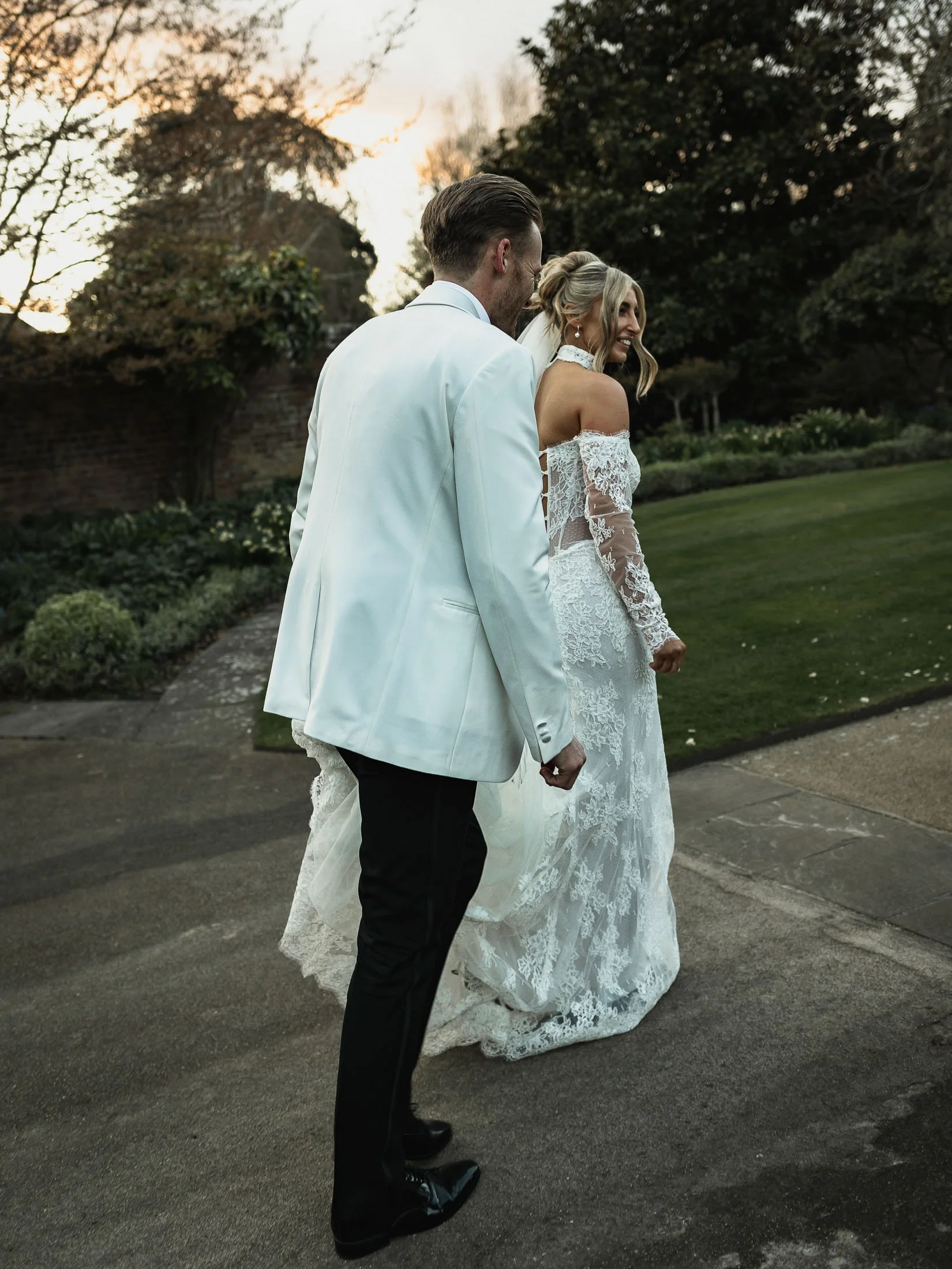 A bride and groom walk towards The Orangery Maidstone after their couples portrait session.