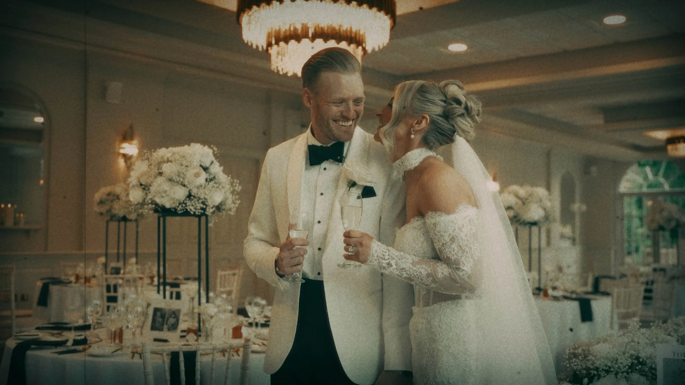 A bride and groom laugh together as they stand in their wedding reception room at The Orangery, Maidstone.