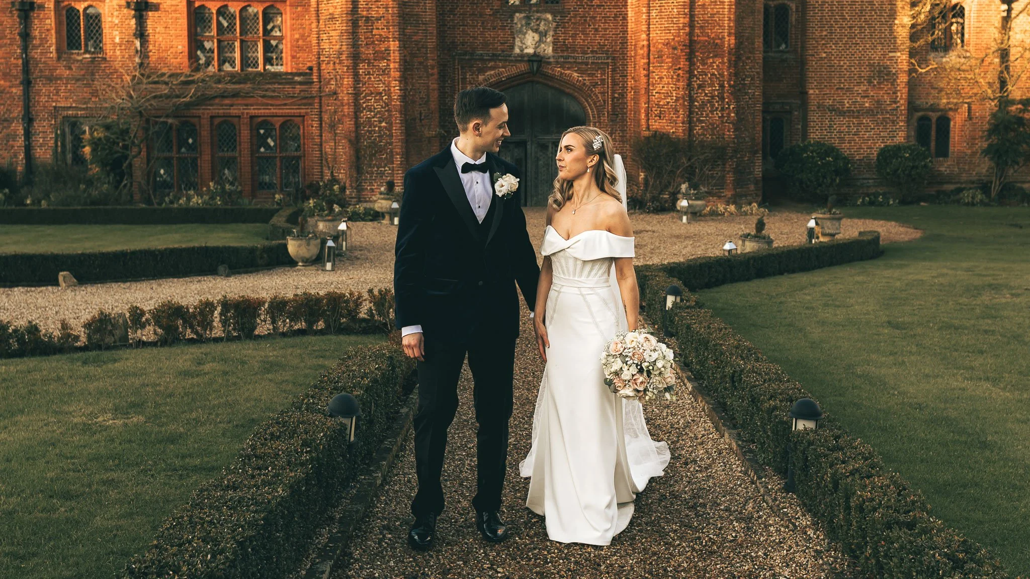 A couple pose outside Leez Priory on their wedding day, captured by an editorial and cinematic photography and videography team.
