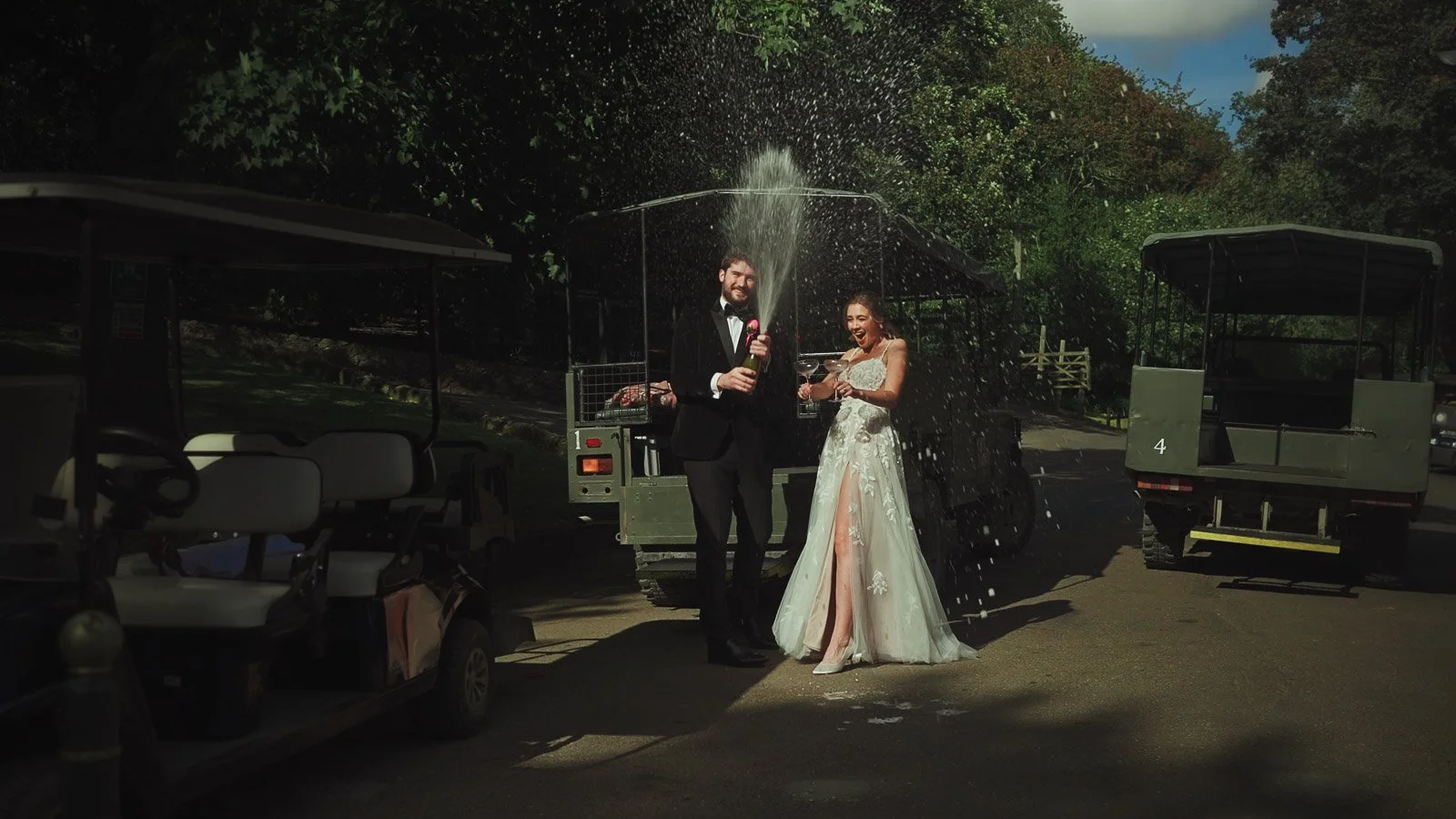 A bride and groom spray Champagne from the bottle before their safari experience at Port Lympne Hotel & Reserve.