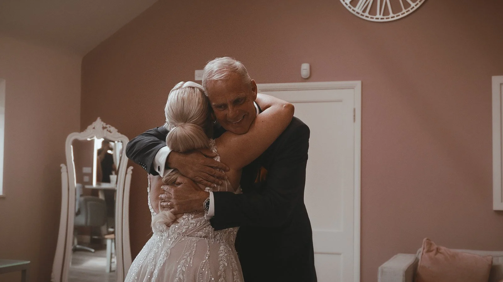 A father embraces his daughter in a highly emotive moment during bridal preparations at Winters Barns in Kent.