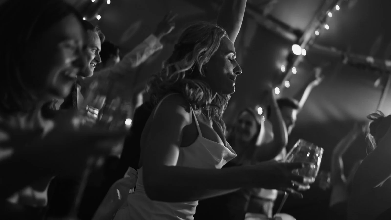 Editorial-style wedding photography from a colourful riverside celebration with bold florals and a marquee reception.