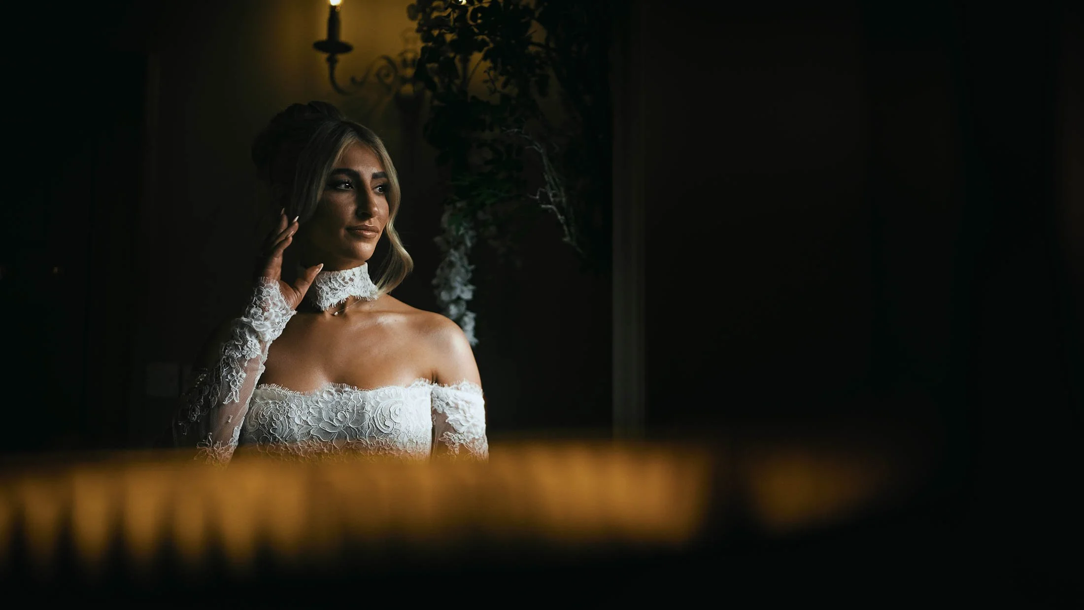 A bride fixes her earring during morning preparations on her wedding day in the UK.