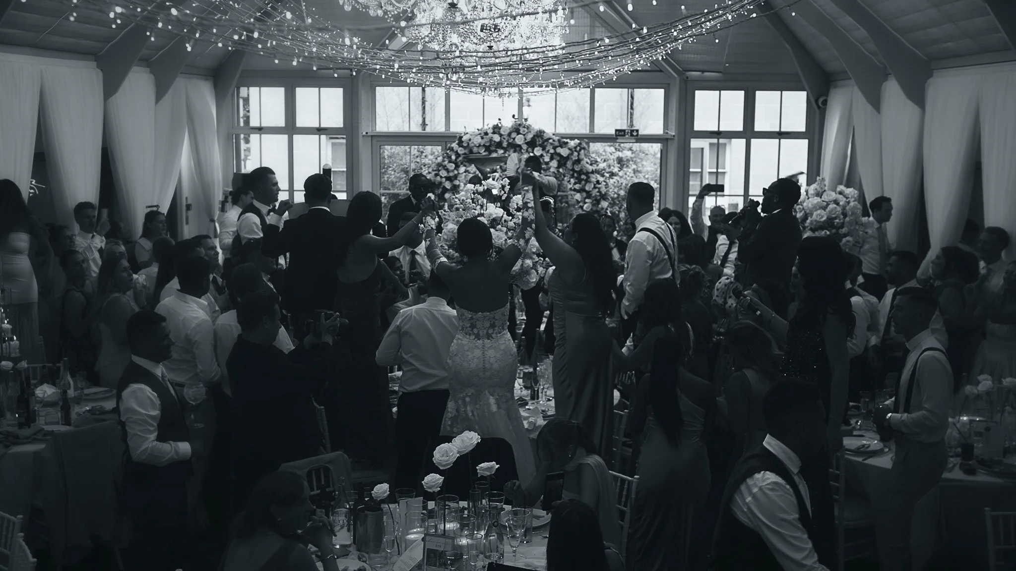 Wide view of the Atrium wedding breakfast at Botleys Mansion showing scale, symmetry and atmosphere.