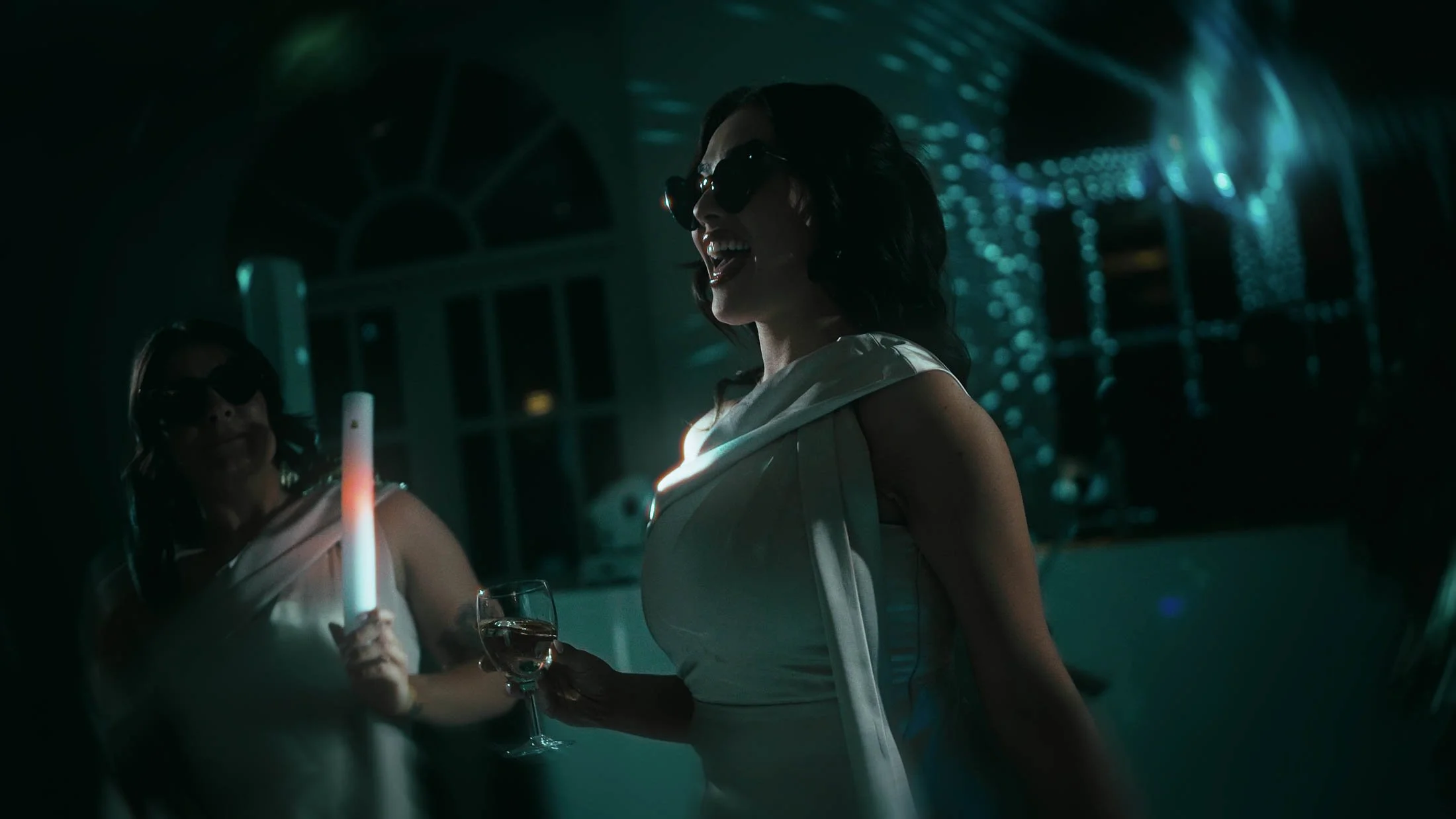 A bridesmaid dances whilst wearing heart-shaped sunglasses during an after party at a wedding at the Orangery, Maidstone.