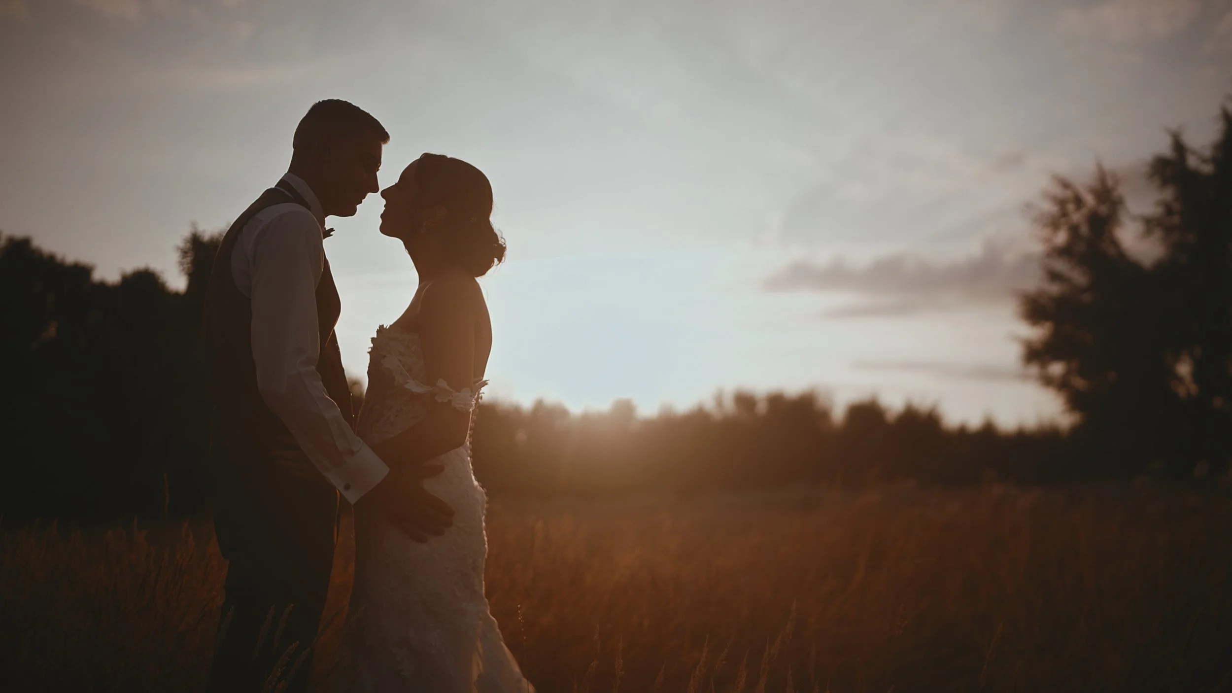 A couple are silouetted against a sunset during their destination wedding in Europe, captured by wedding videographer Luke Batchelor productions.