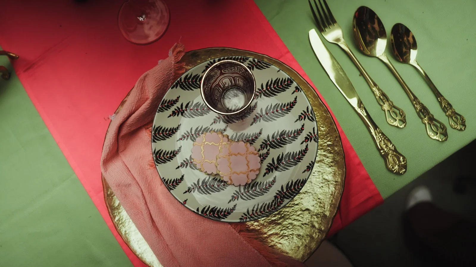 Table scape and place setting detail shot showing pink, red and gold colour palette.