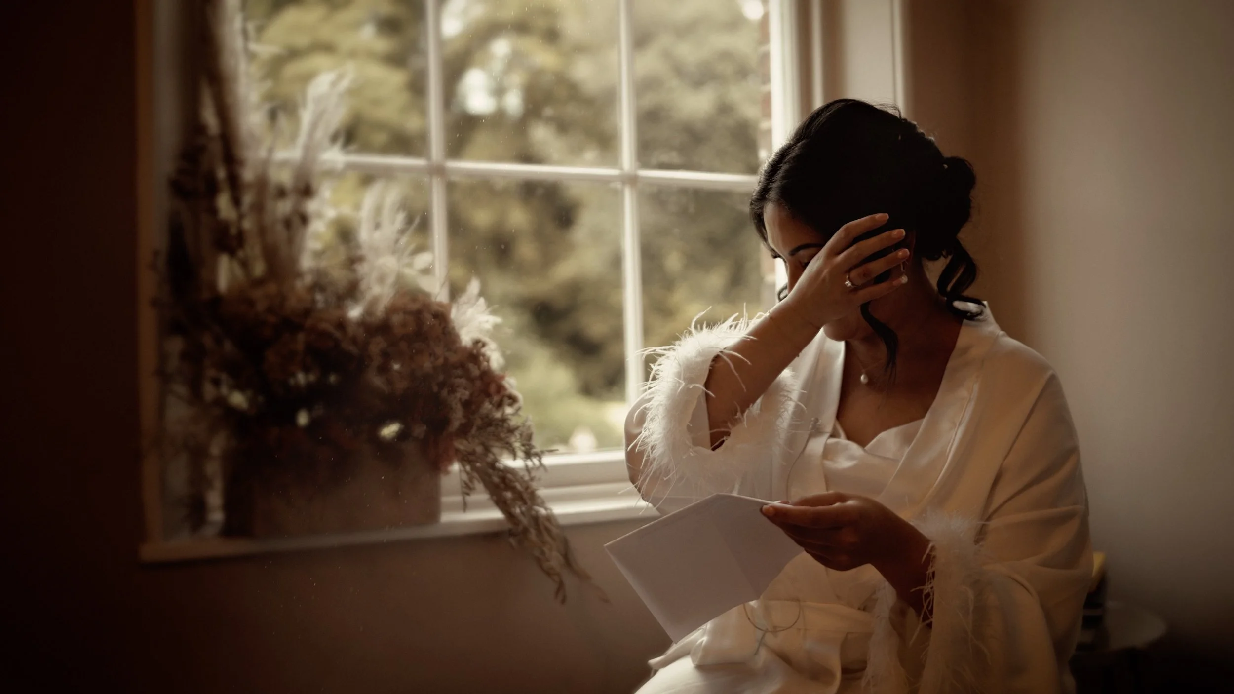 Emotional bride crying during wedding preparations as she reads a letter from the groom at The Orangery Maidstone in Kent