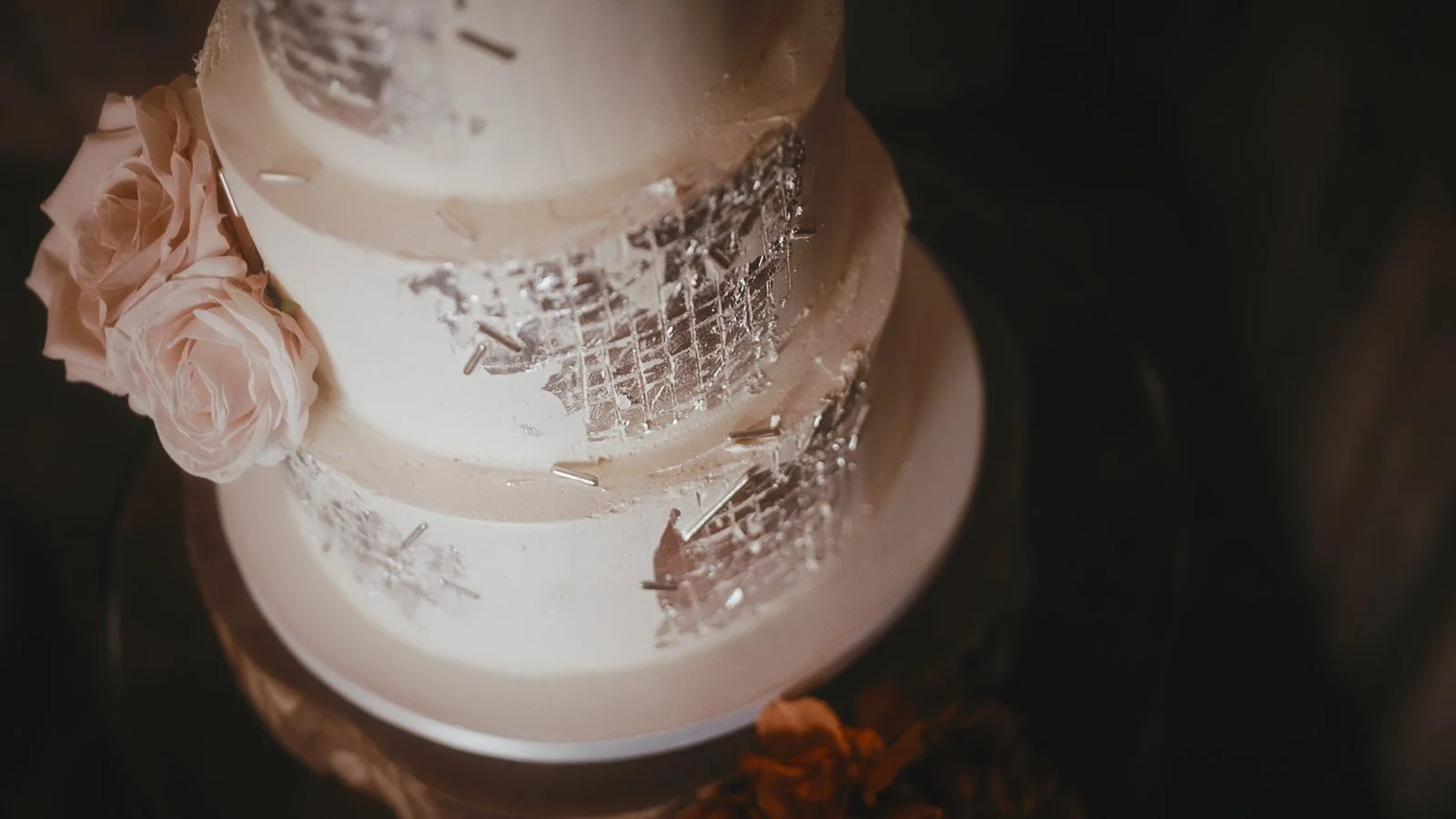 Close up detailing on a luxurious wedding cake, in an editorial style from a colourful Winters Barns wedding film.