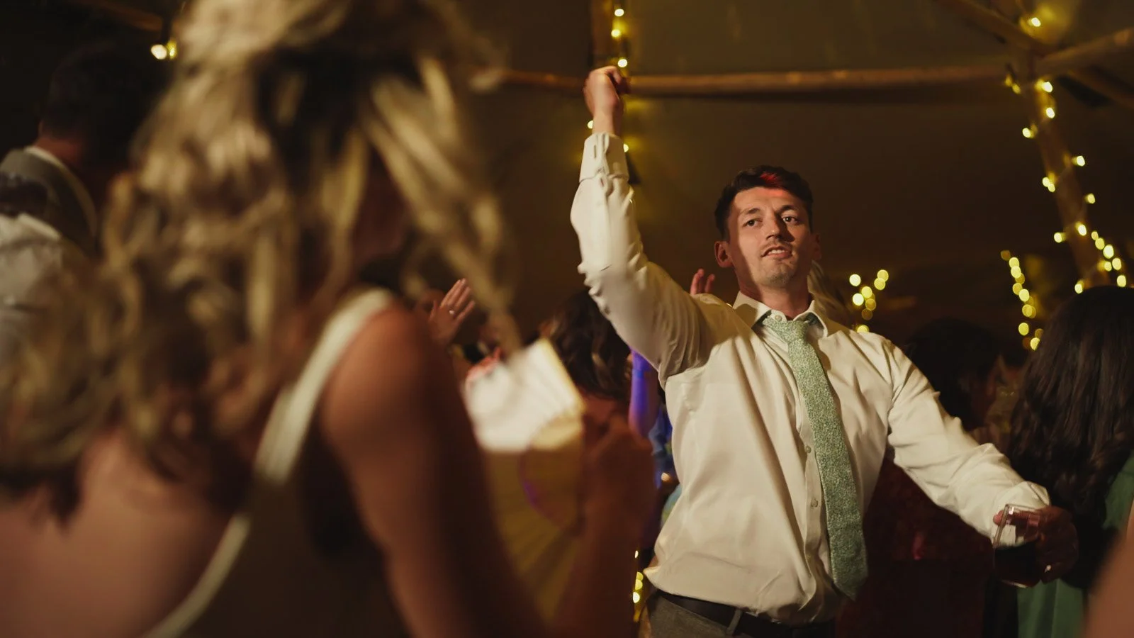 Editorial-style wedding photography from a colourful riverside celebration with bold florals and a marquee reception.