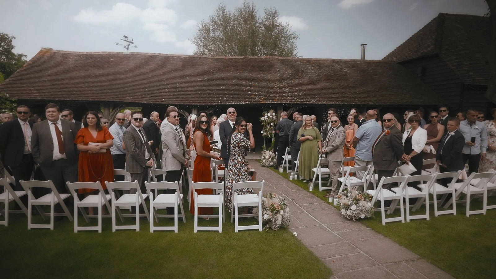 Rachel and Ryan’s outdoor ceremony at Winters Barns with guests seated along the floral-lined aisle.