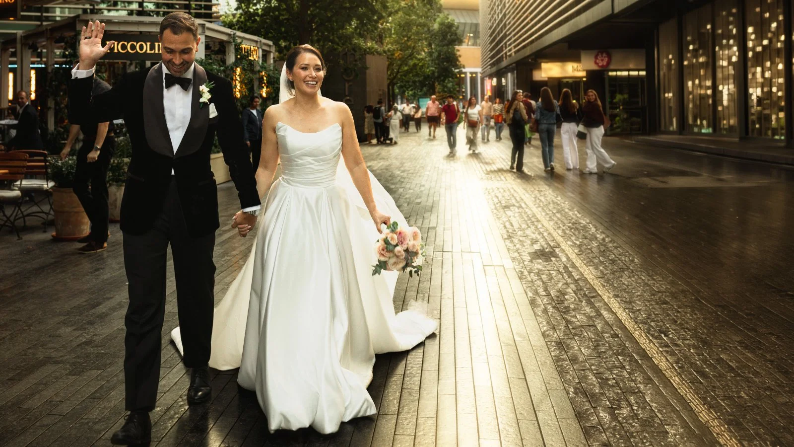 A bride and groom walking through the streets of London Bridge on their black tie wedding day in London.