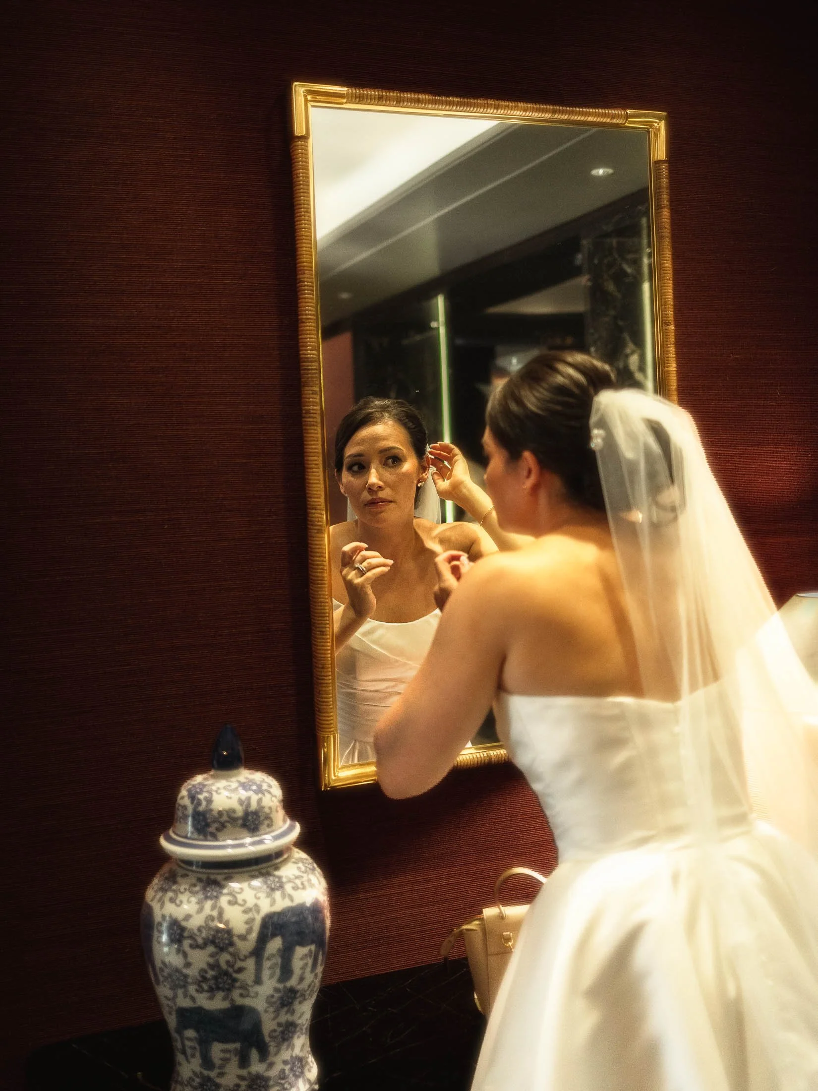 A bride fixes her make up in a large mirror in the foyer of the Shangri-La The Shard hotel in London.