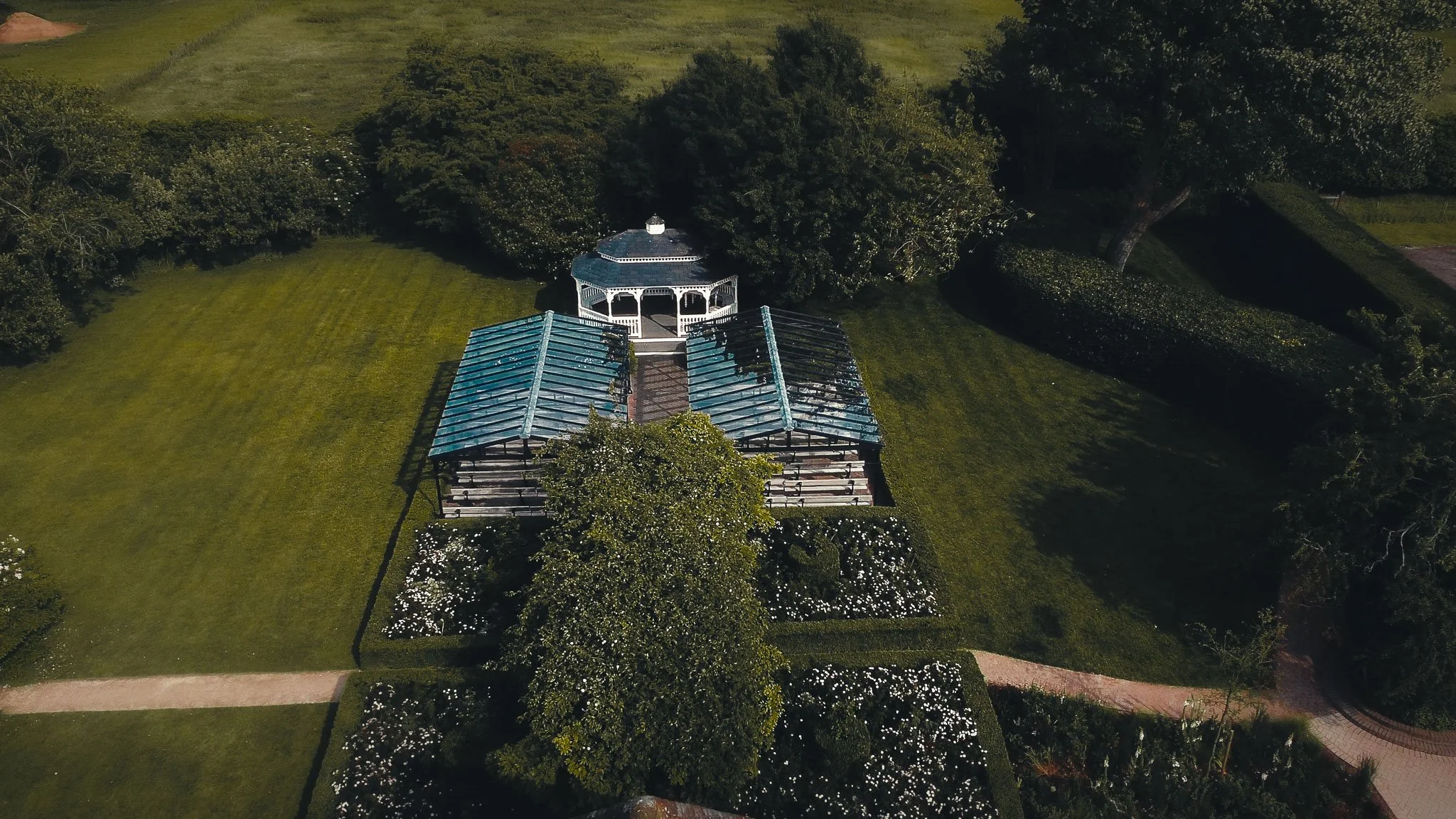 Outdoor ceremony at The Old Kent Barn gazebo in Kent with guests seated in the garden