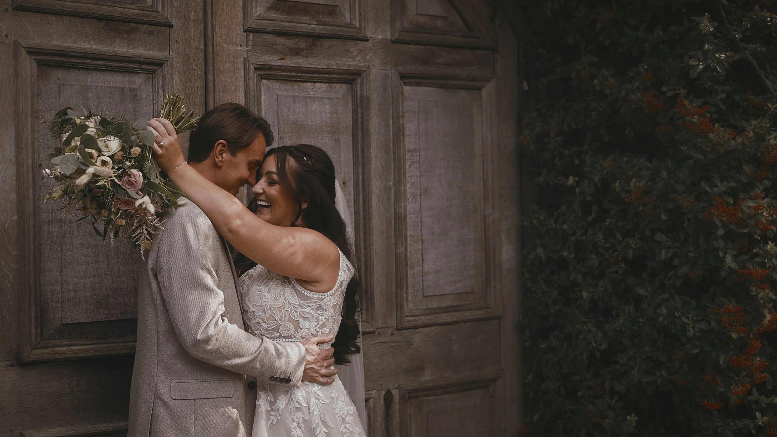 A bride laughs heartily with her arms wrapped around the groom in an editorial moment from their September Winters Barns wedding film.