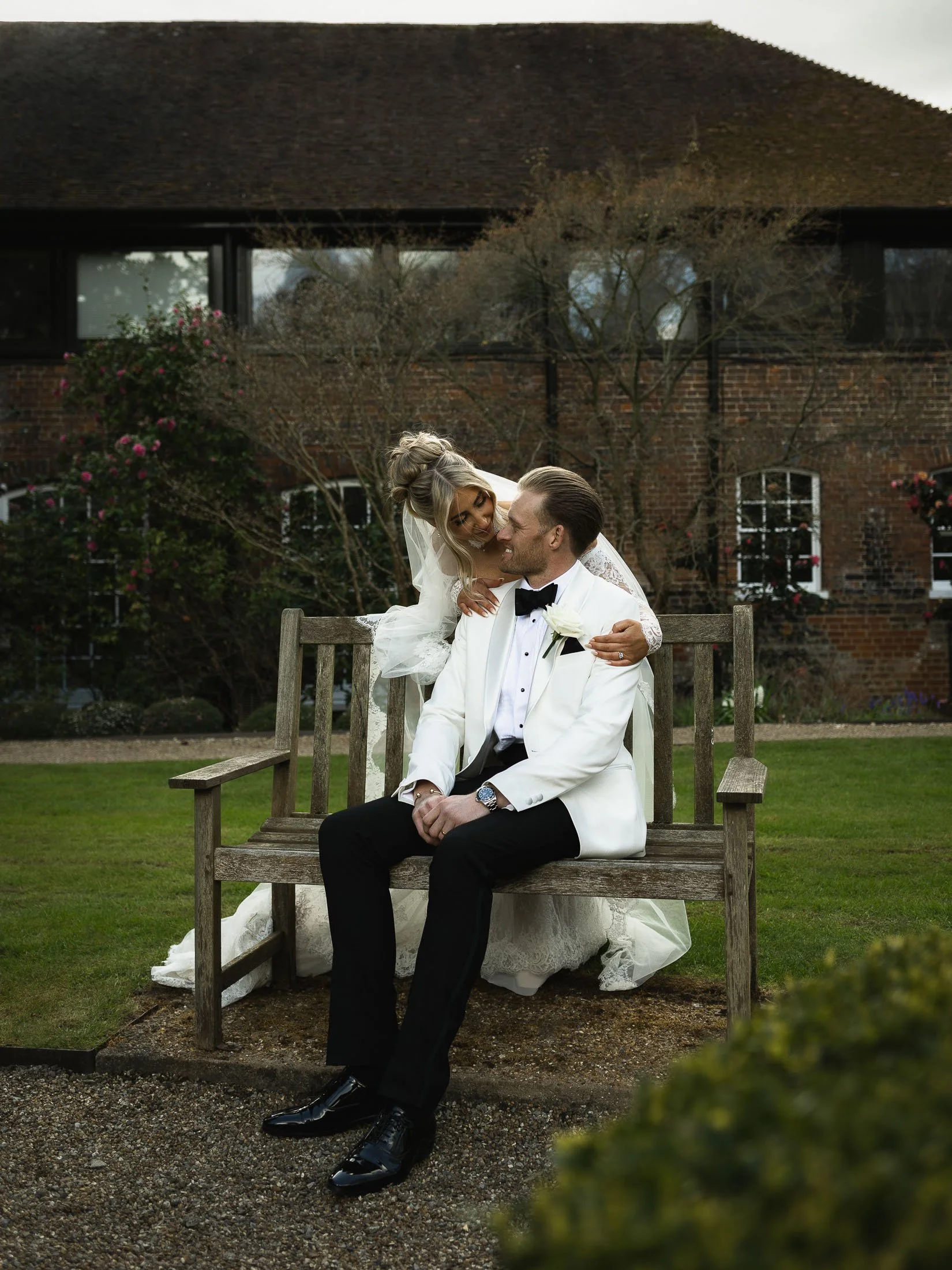 Editorial wedding photo and film team capturing a bride and groom on a bench at The orangery Maidstone, Kent.