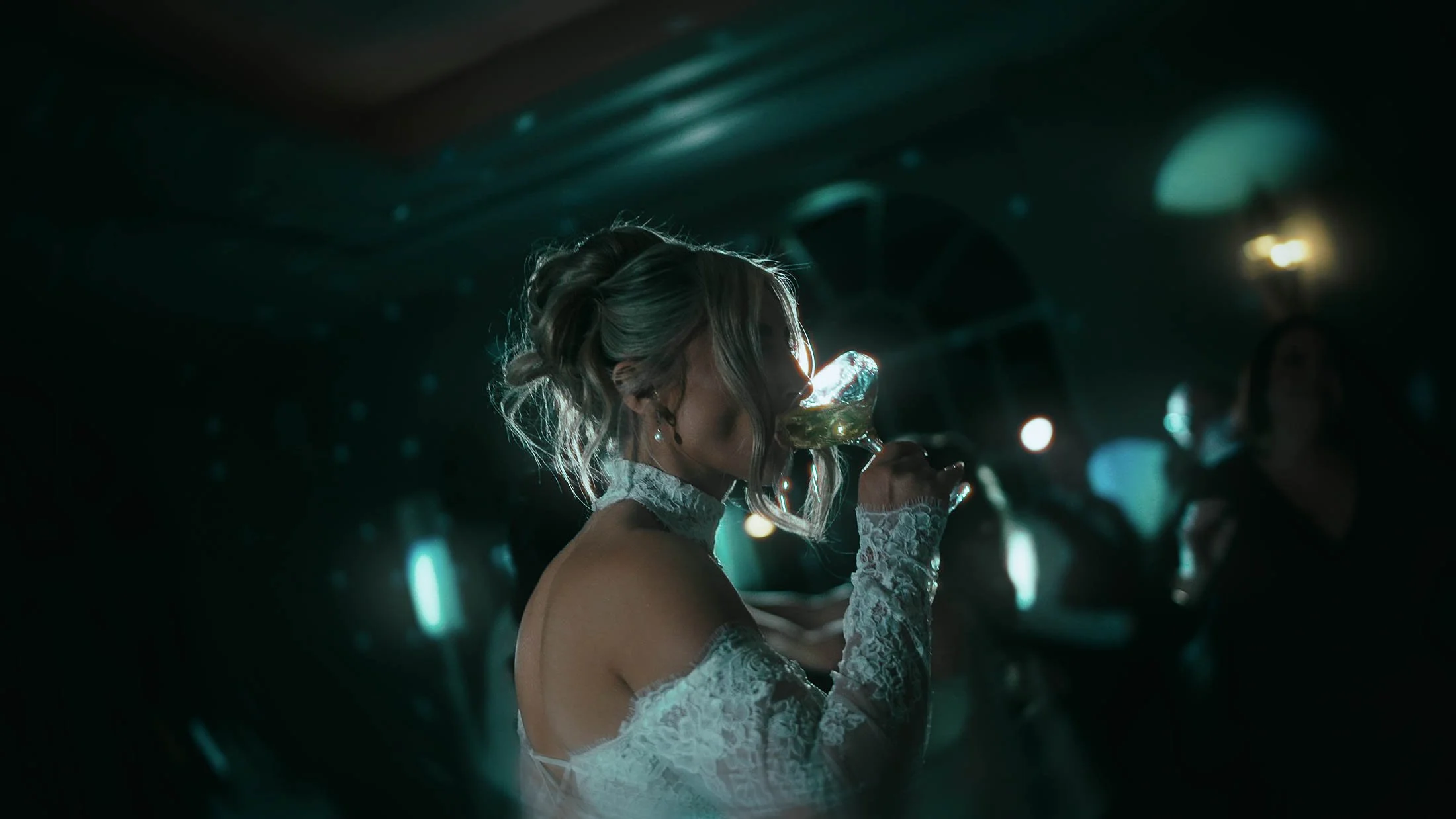 A bride sips her drink from a martini glass during a wedding after party at The Orangery, Maidstone.