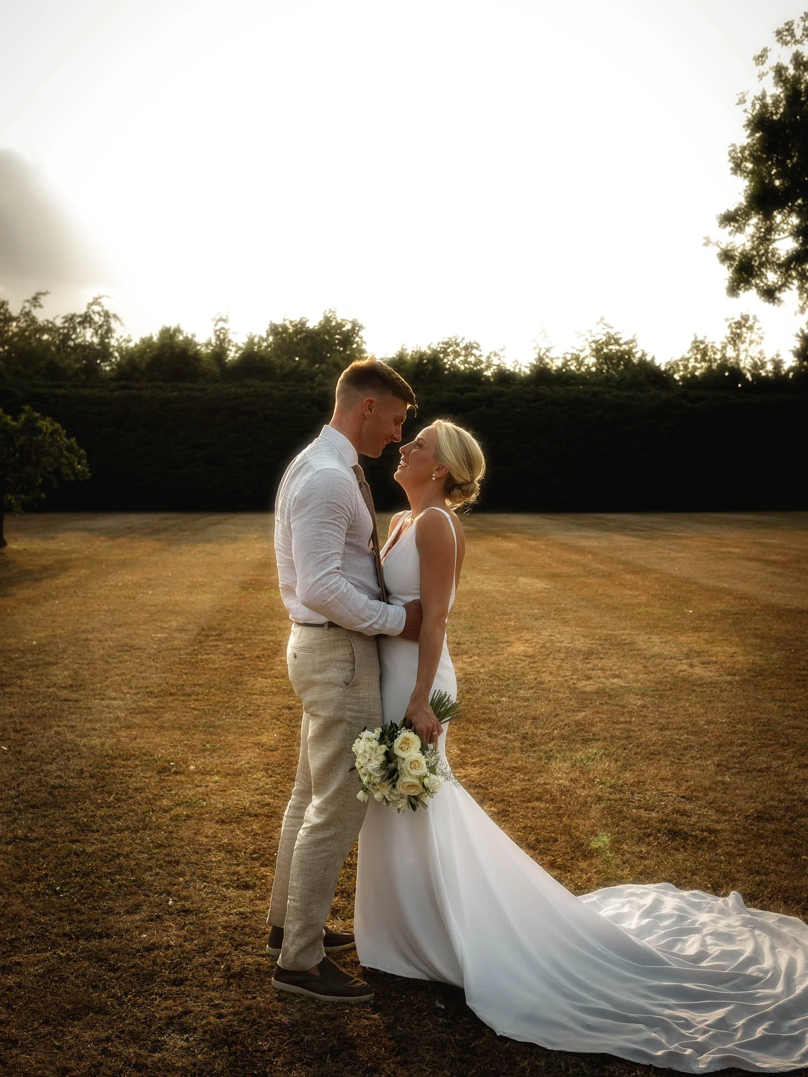A golden hour portrait at Winters Barns wedding venue as the groom holds the waist of his bride.