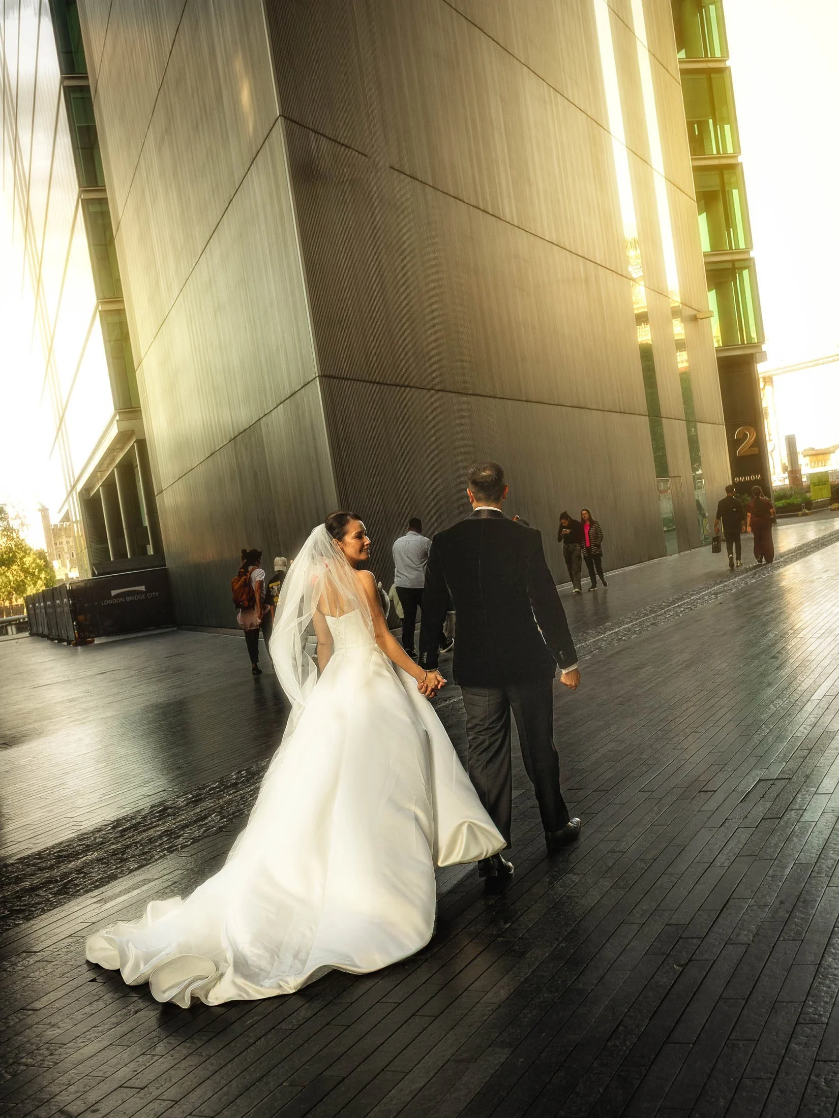 A natural and editorial London wedding moment as a bride and groom walk through the streets surrounding London Bridge.