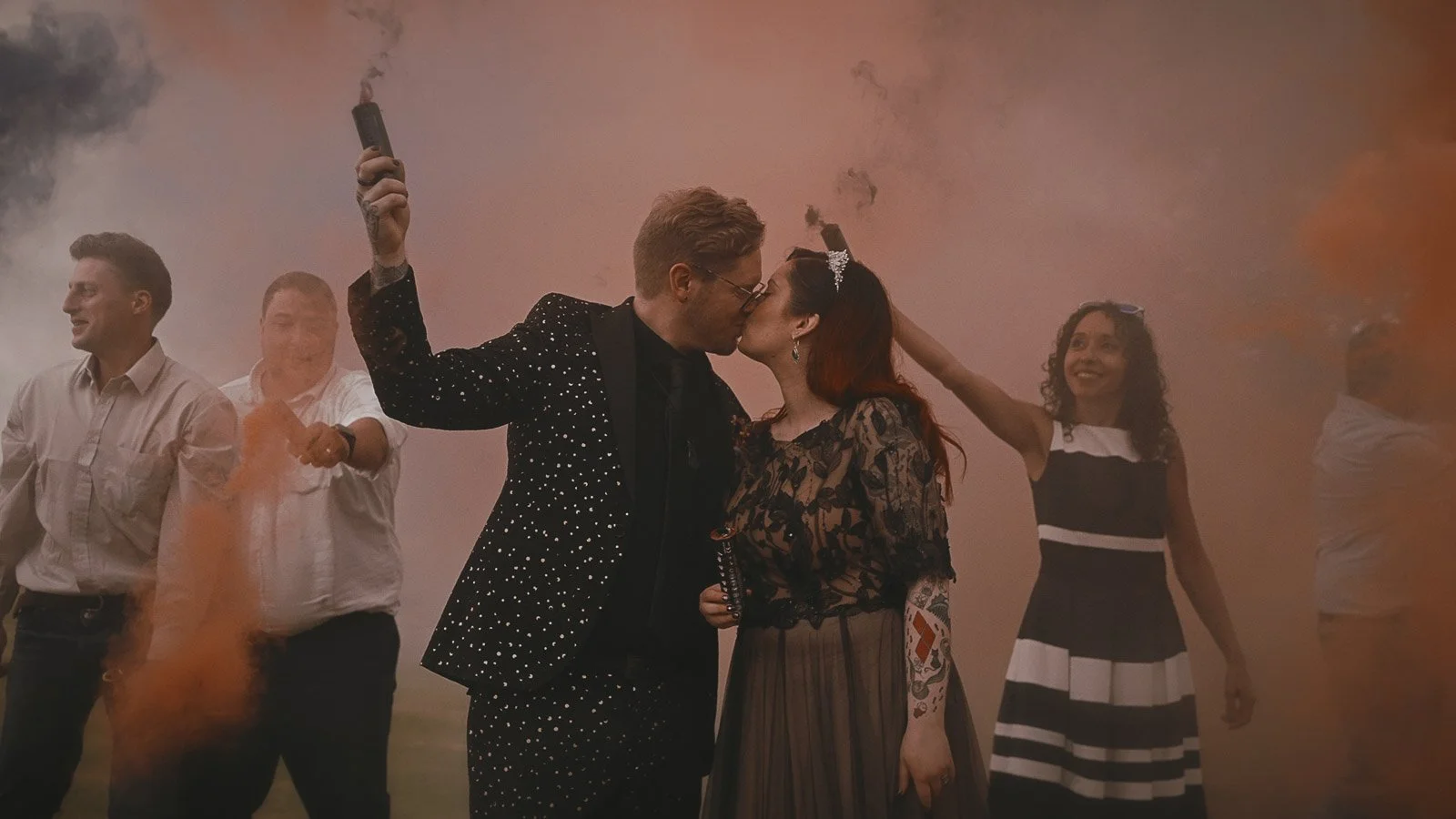 Couple framed by smoke bomb colour for bold alternative wedding film imagery