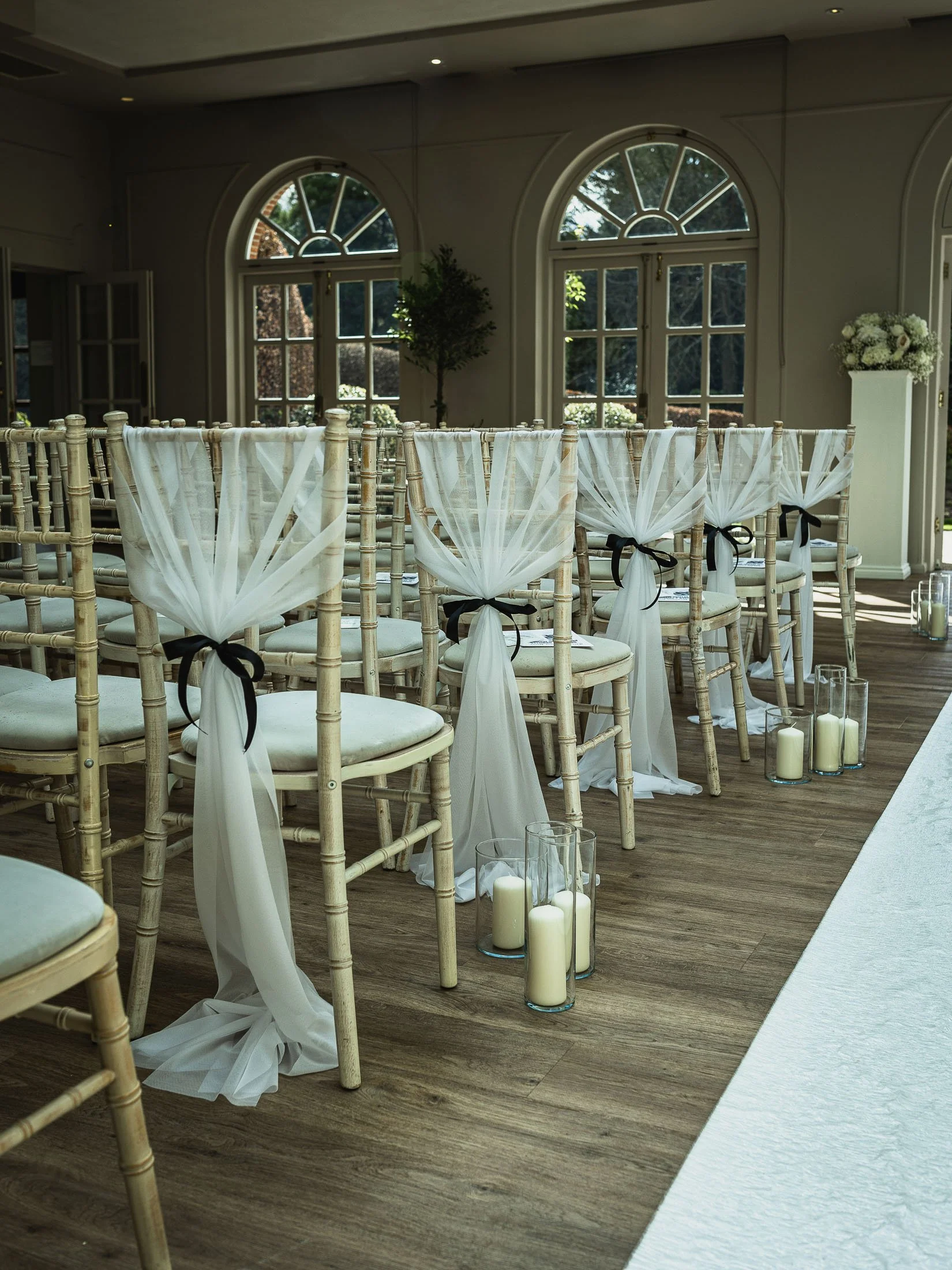 Indoor wedding ceremony decor and chair covers at The Orangery Maidstone wedding venue in Kent.