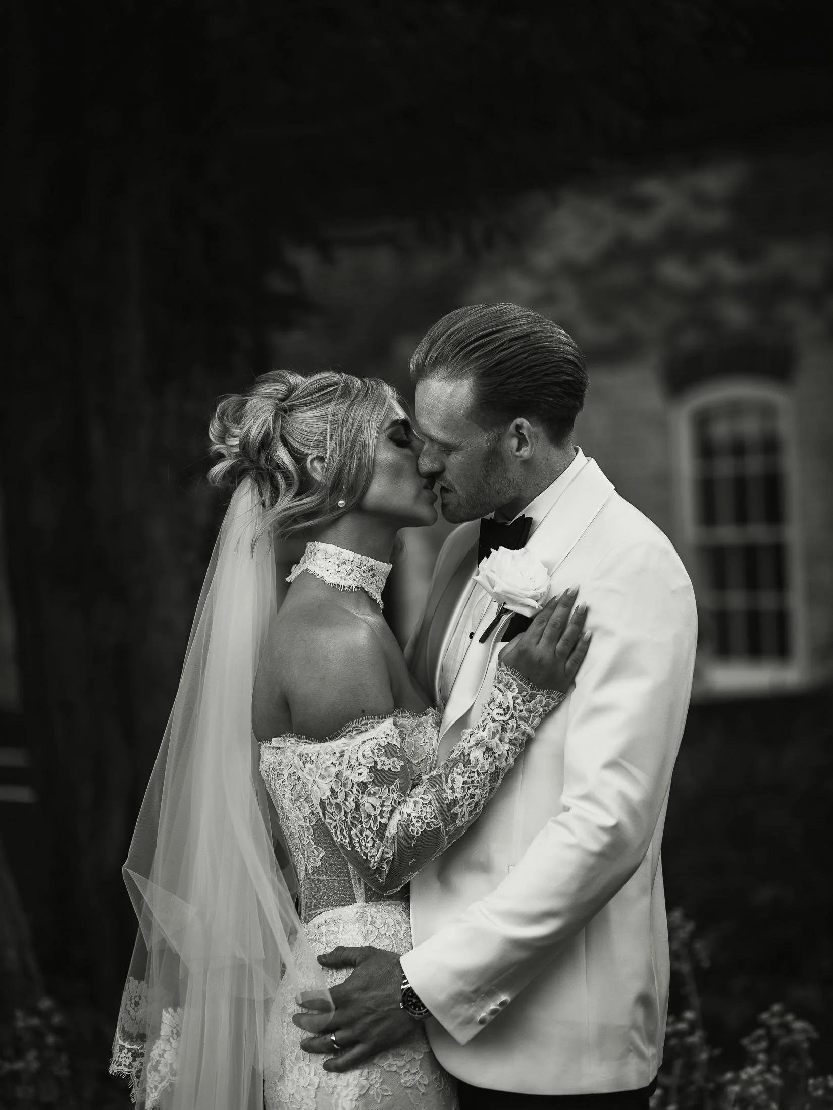 White tuxedo groom and bride embrace each other at The Orangery Maidstone in an editorial-style wedding moment.