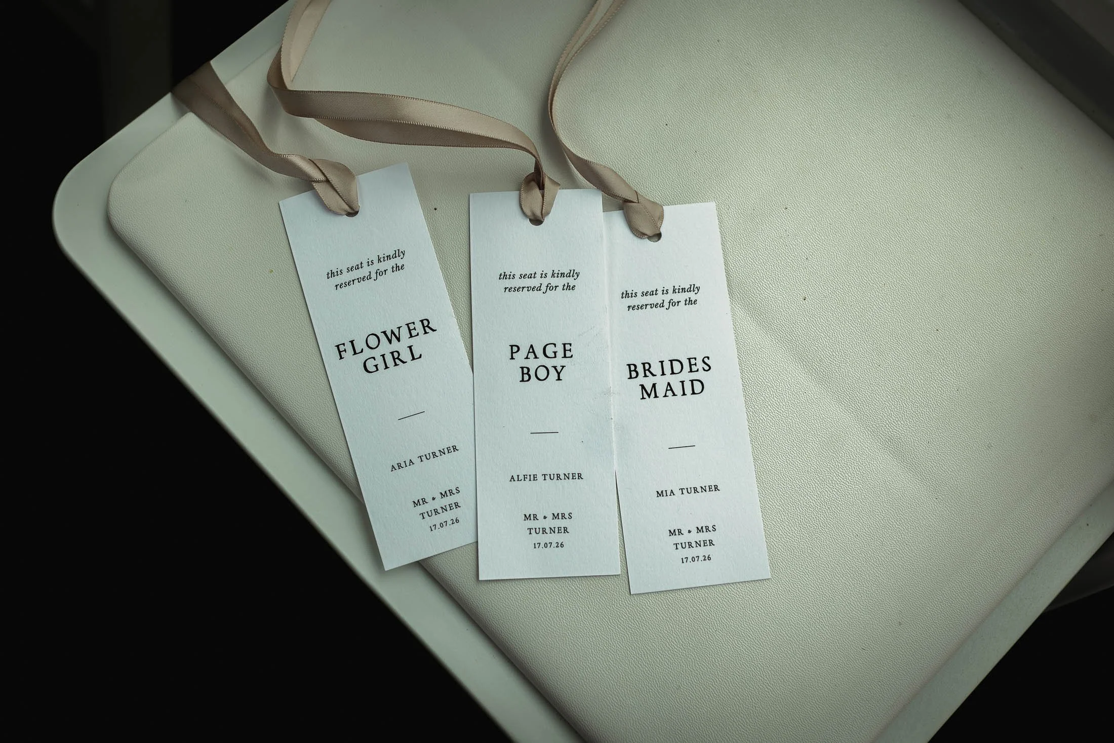 Seat place cards sit on the chairs of an outdoor summer wedding ceremony at Winters Barns in Kent.