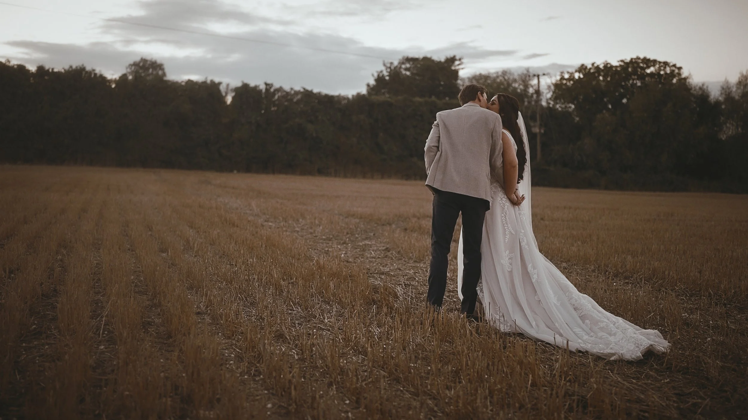 A bride and groom walk together at golden hour during their September wedding at Winters Barns in Canterbury.