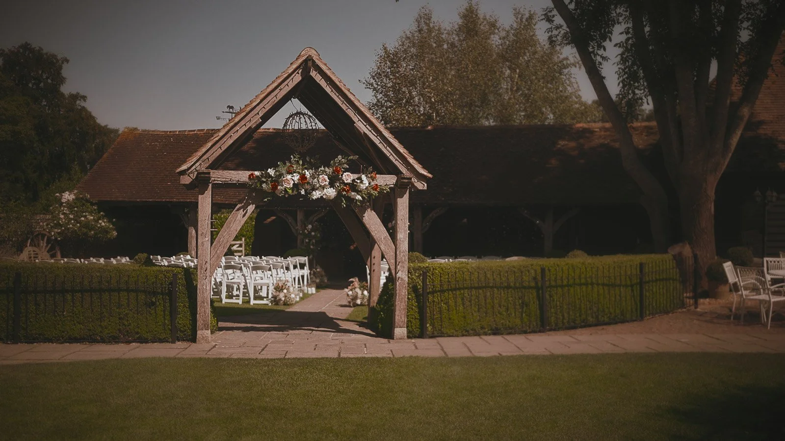 Establishing shot of the outdoor ceremony area at Winters Barns in Canterbury, taken from a colourful wedding film.