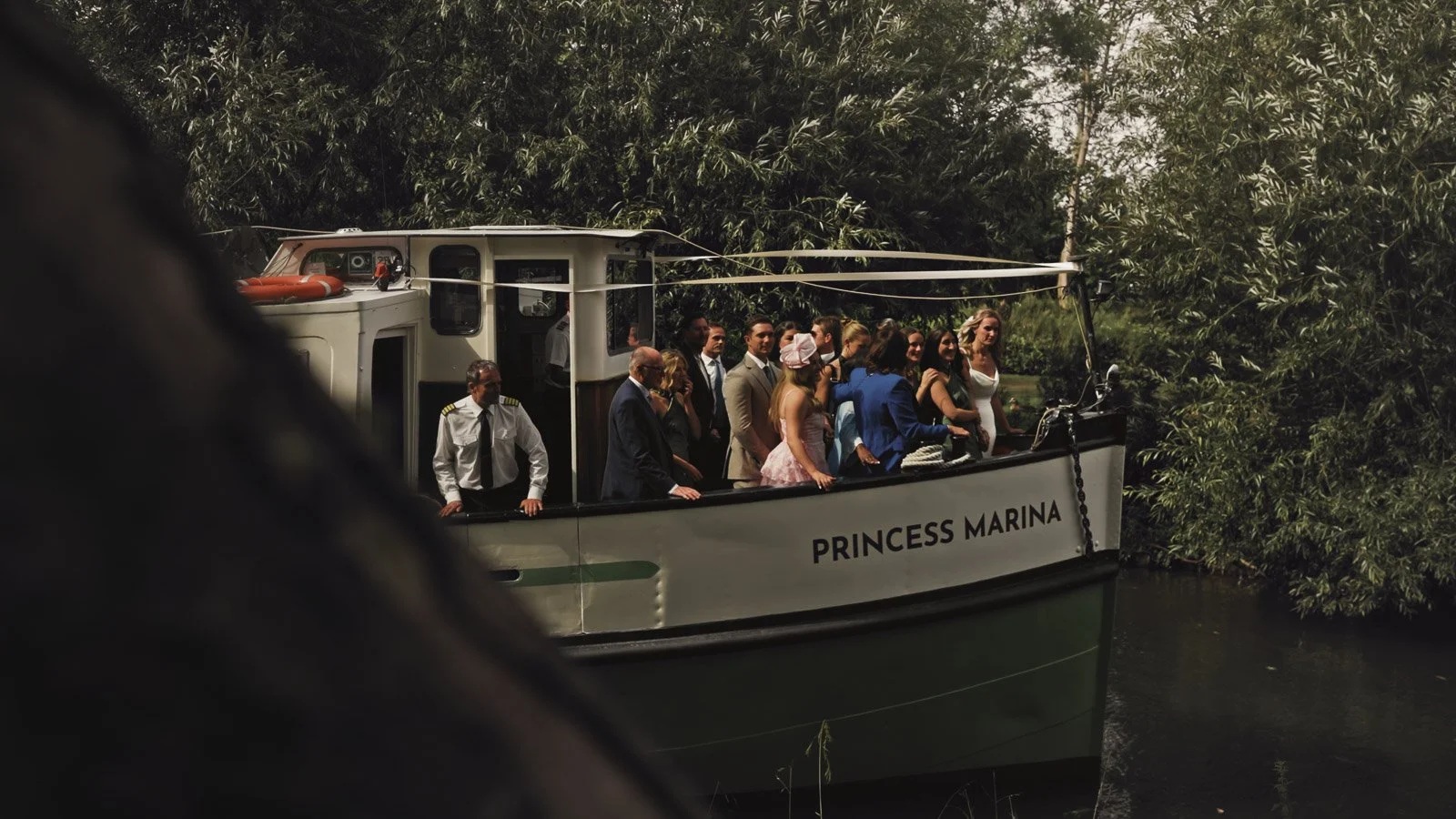 A bride and guests arrive by boat along the River Thames to an Oxfordshire country estate for a riverside wedding.
