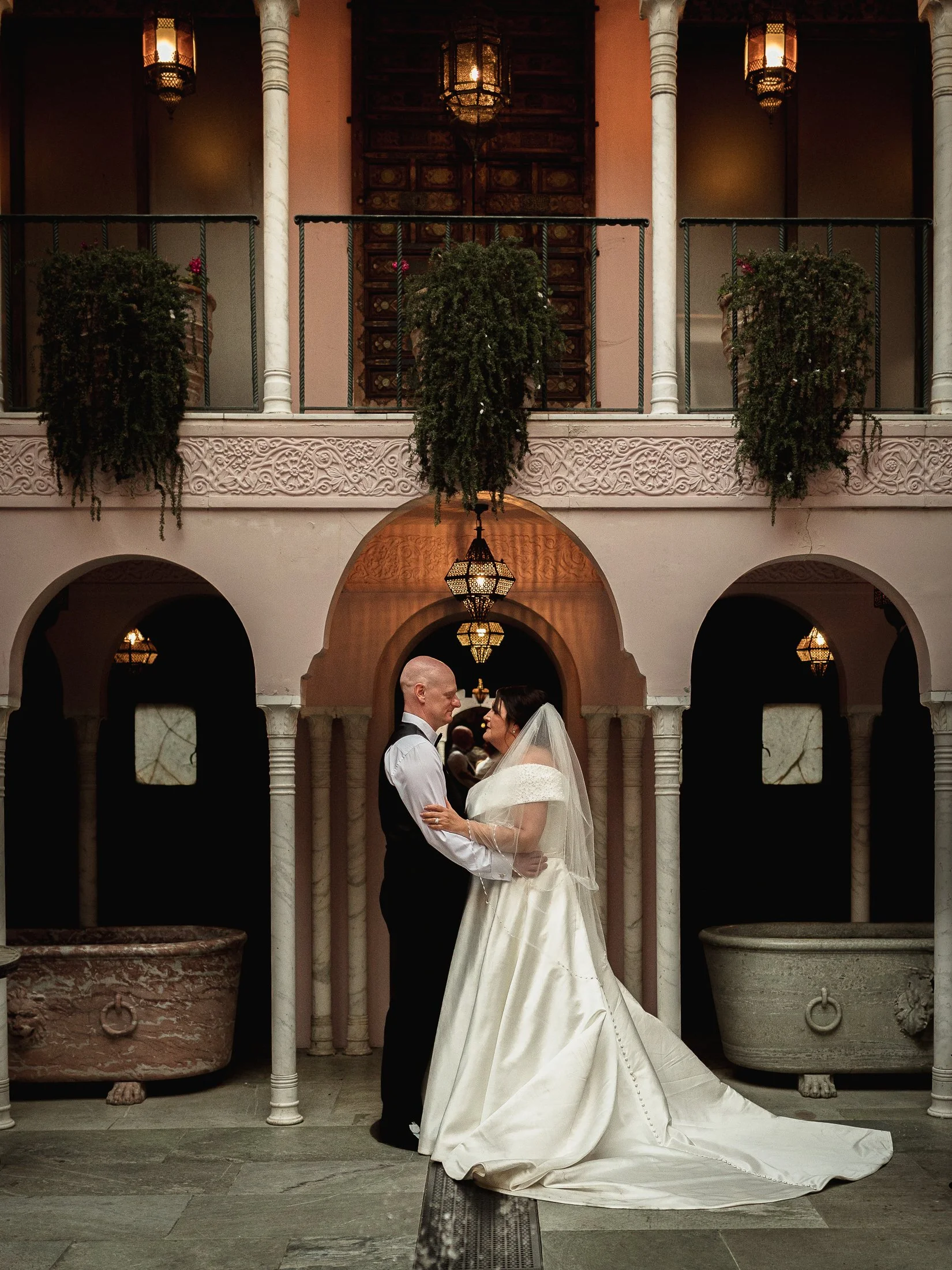 A couple pose together in the Moroccan Courtyard at their Port Lympne Hotle wedding.