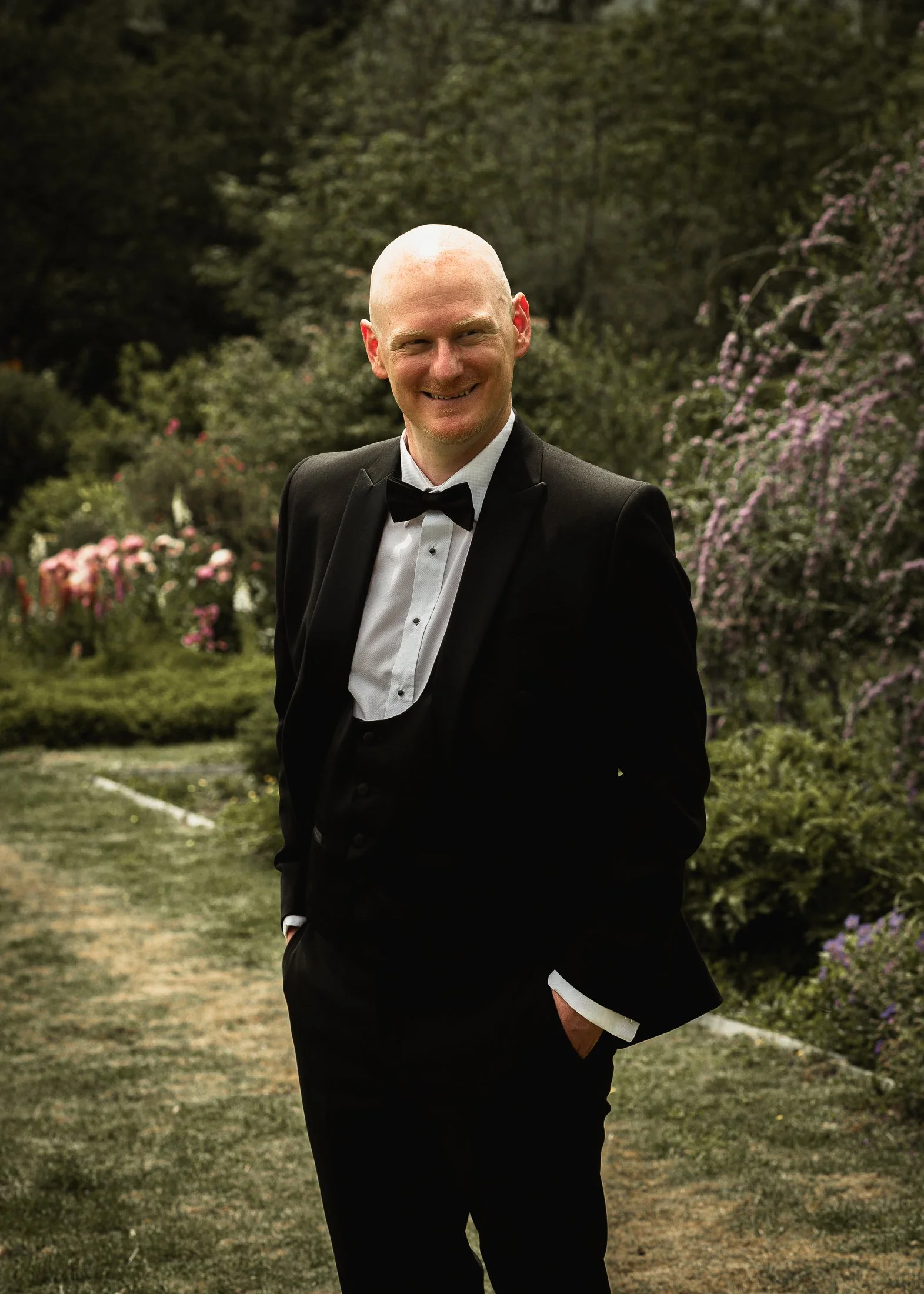 A portrait of groom Luke in his black tie tuxedo in the grounds of Port Lympne Hotel.