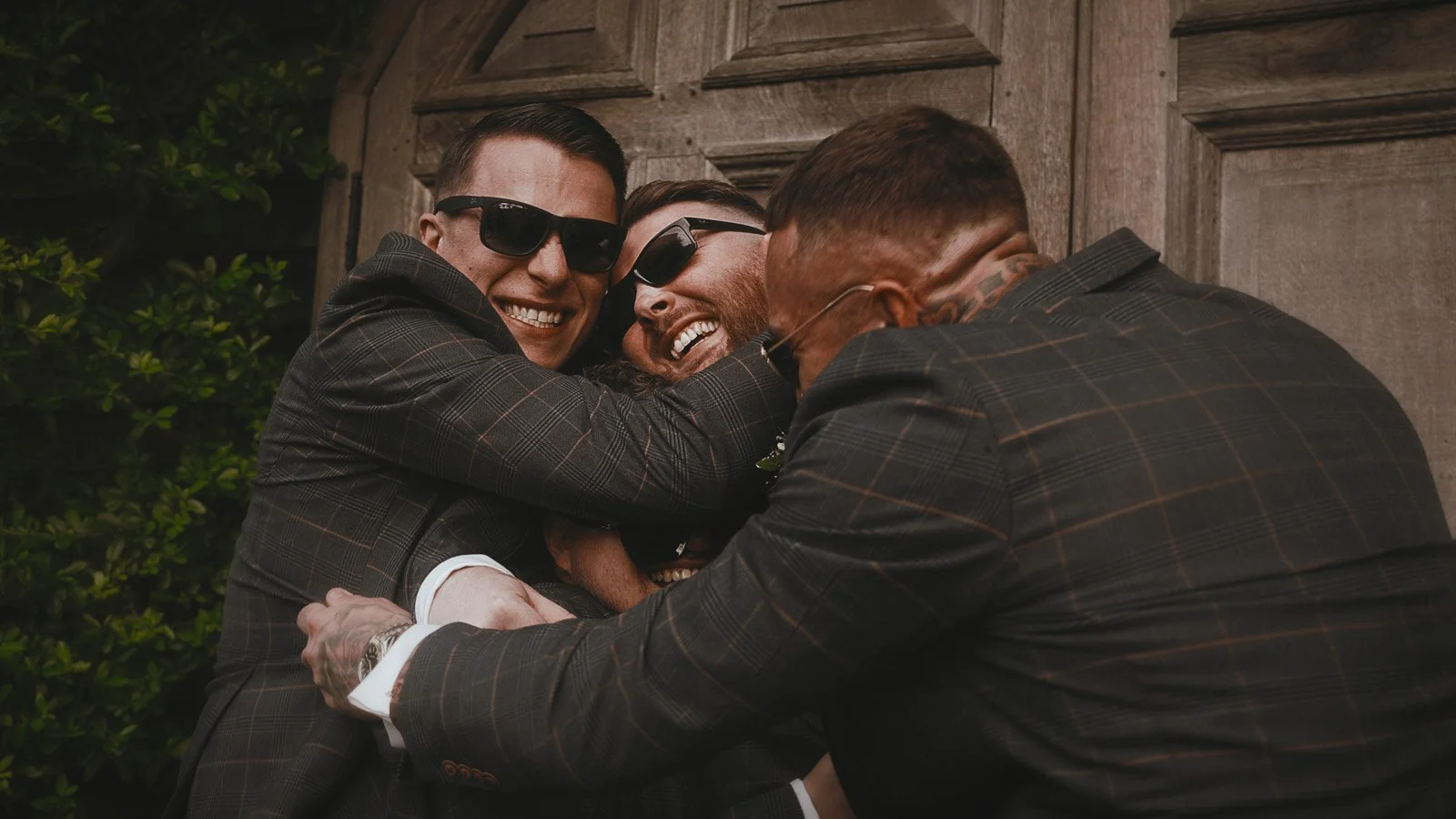 Groom and groomsmen in coordinated suits on the lawns at Winters Barns wedding venue.