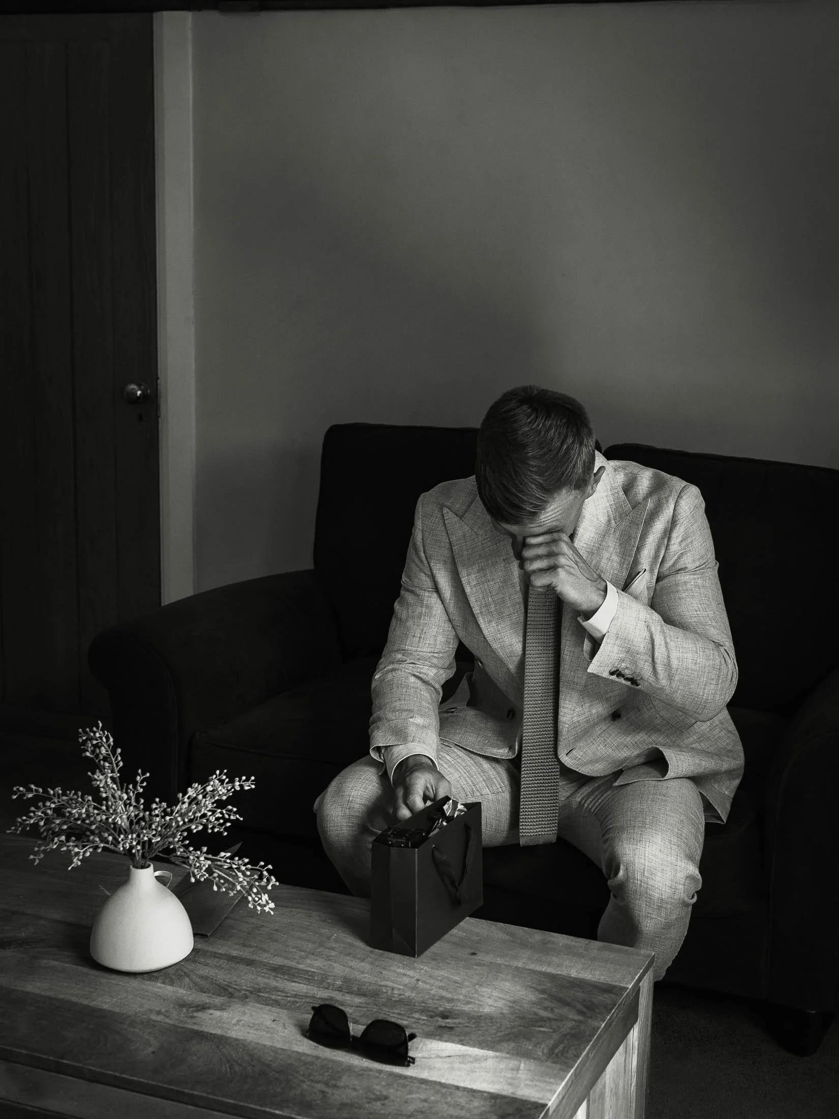 A groom wipes tears from his eyes as he reads a letter from his bride, captured on the morning of his wedding day at Winters Barns in Kent.