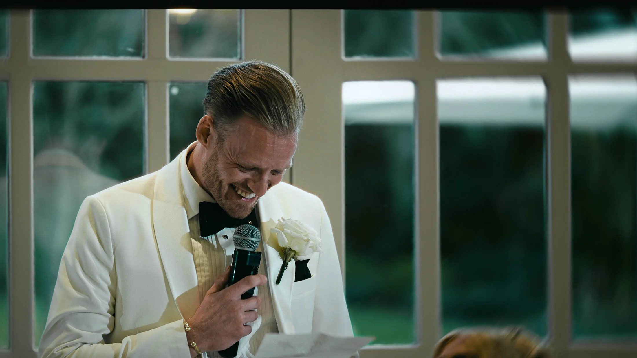 The groom laughs as he delivers his speech to the bride during his wedding day at The Orangery Maidstone.