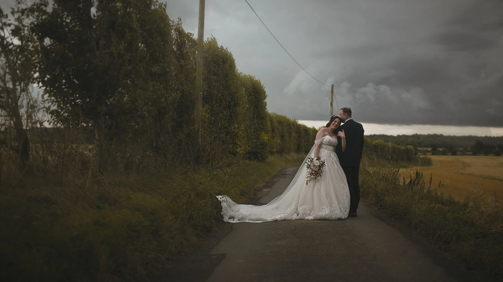 Dramatic sunset sky behind couple portraits filmed near Cooling Castle Barn