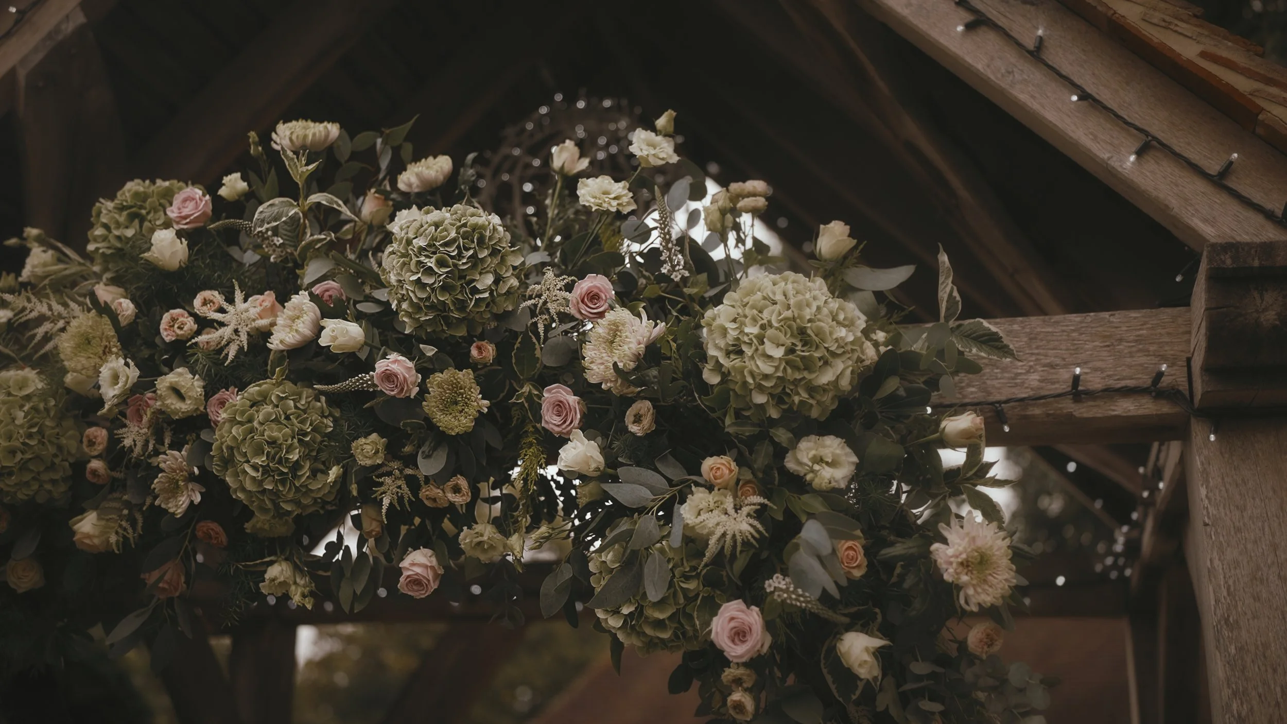 Large green, pink and white florals mark the entrance to an outdoor wedding ceremony at Winters Barns.