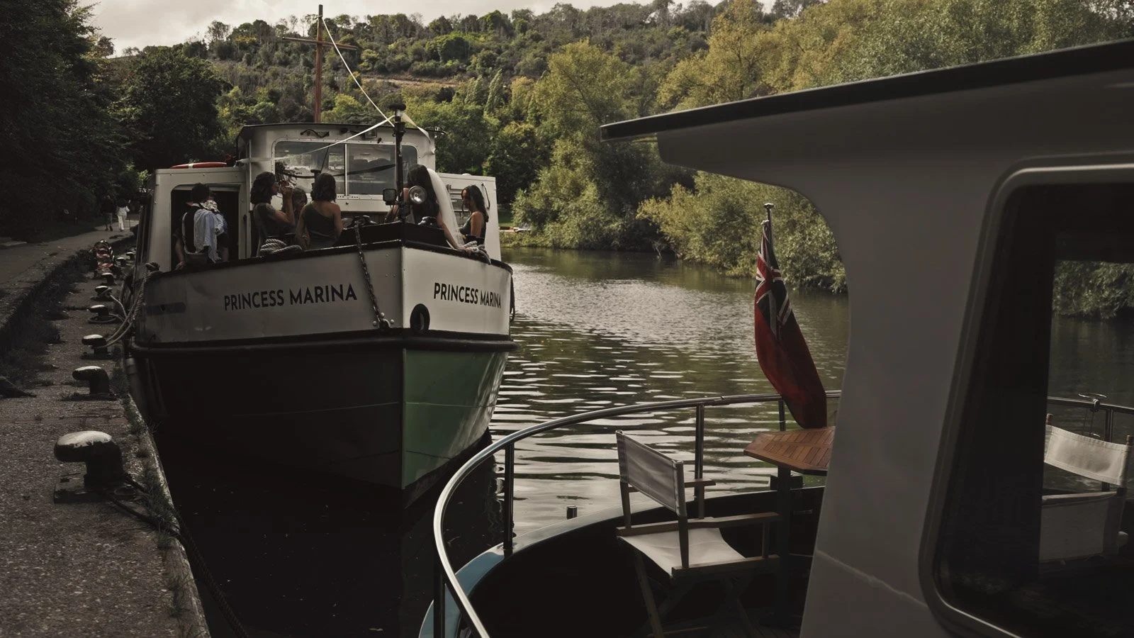 Editorial-style wedding photography from a colourful riverside celebration with bold florals and a marquee reception.