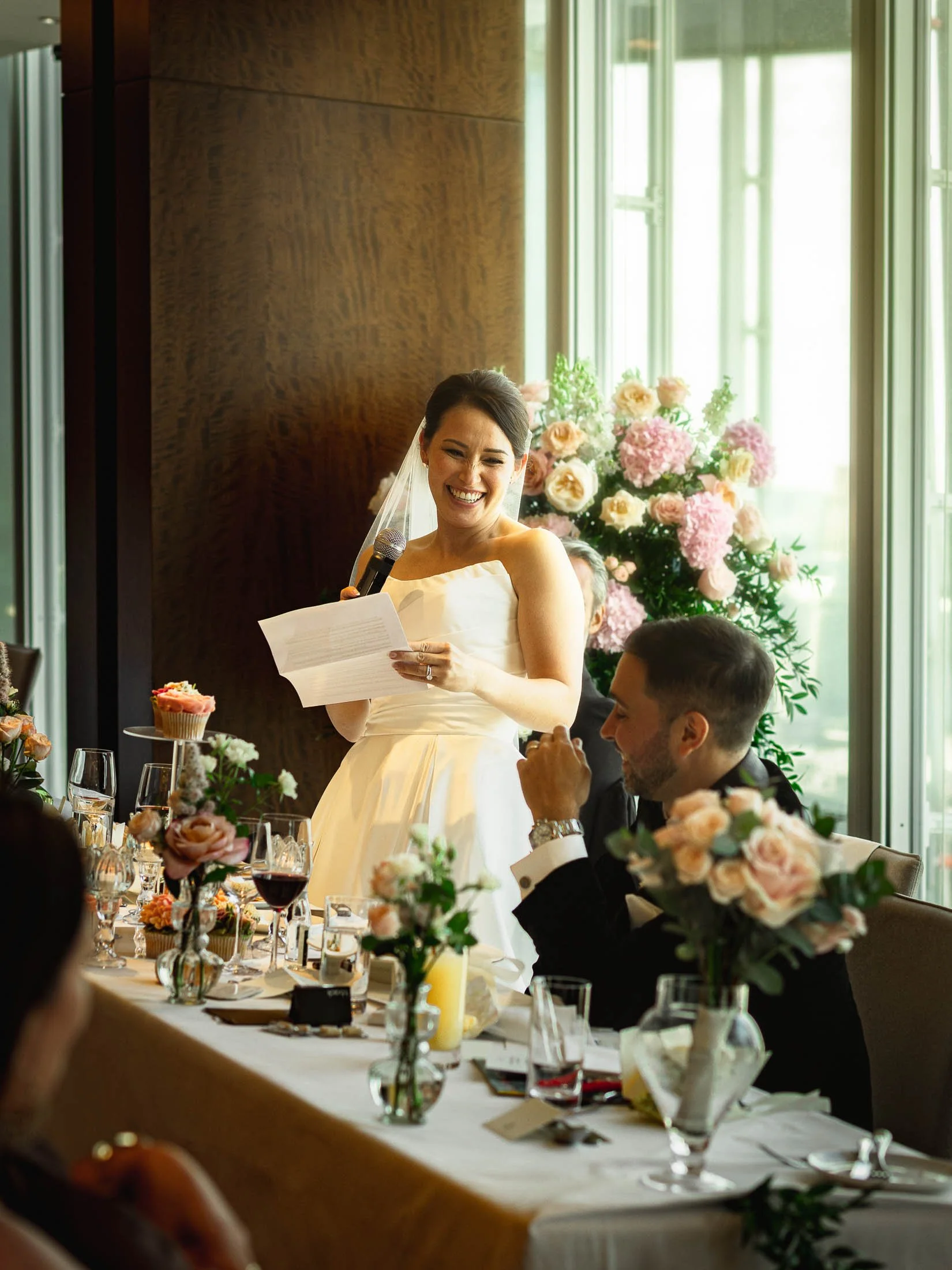 A bride stands up and delivers a speech to her groom and guests during her London wedding at The Shard.