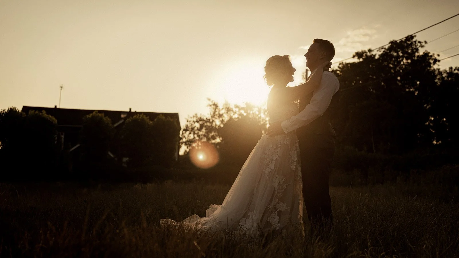 Golden hour couple portraits filmed at Cooling Castle Barn wedding in Kent as the couple are silhouetted against the setting sun.