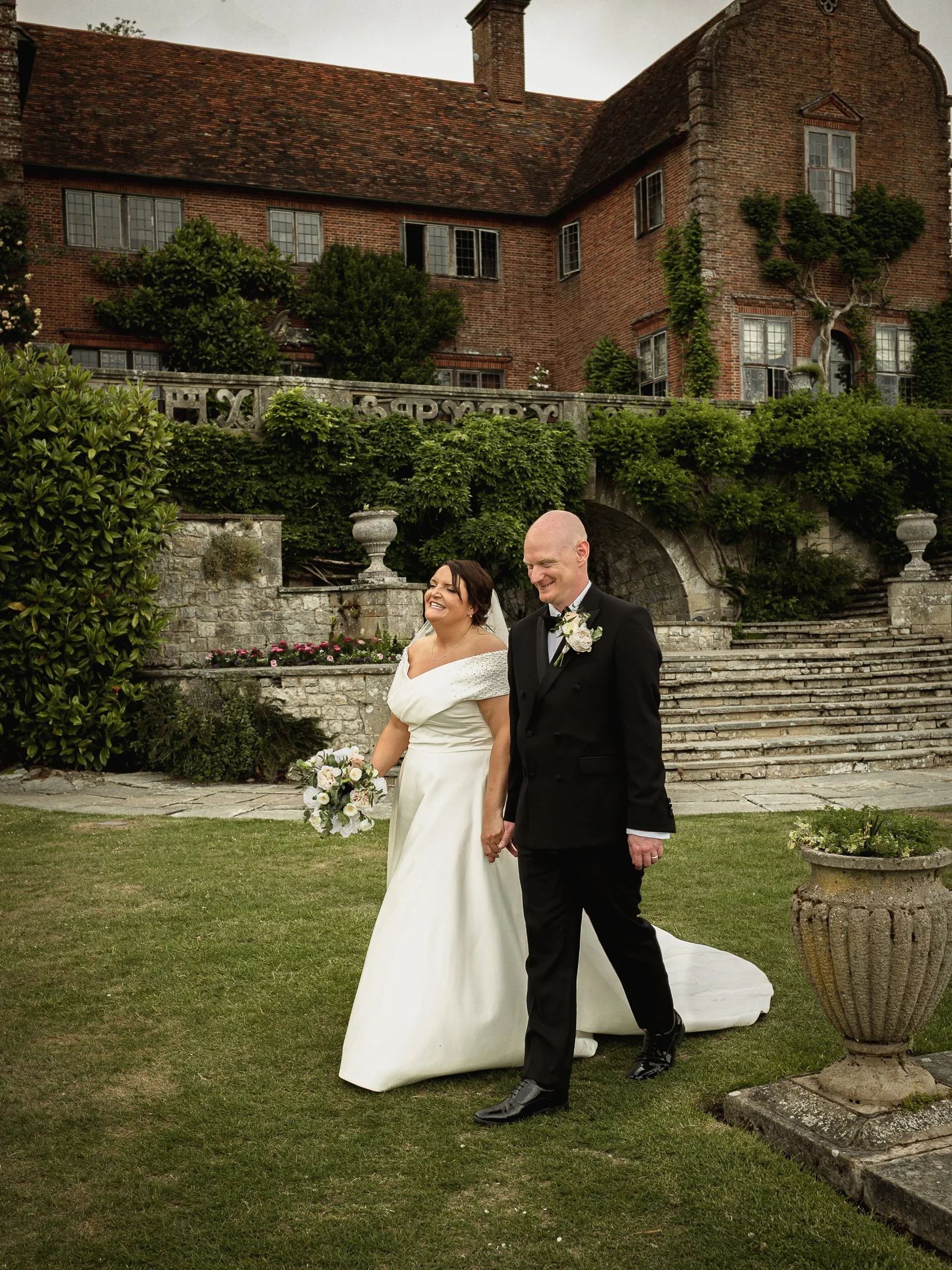 bride-groom-walking-grounds-port-lympne-wedding.jpg