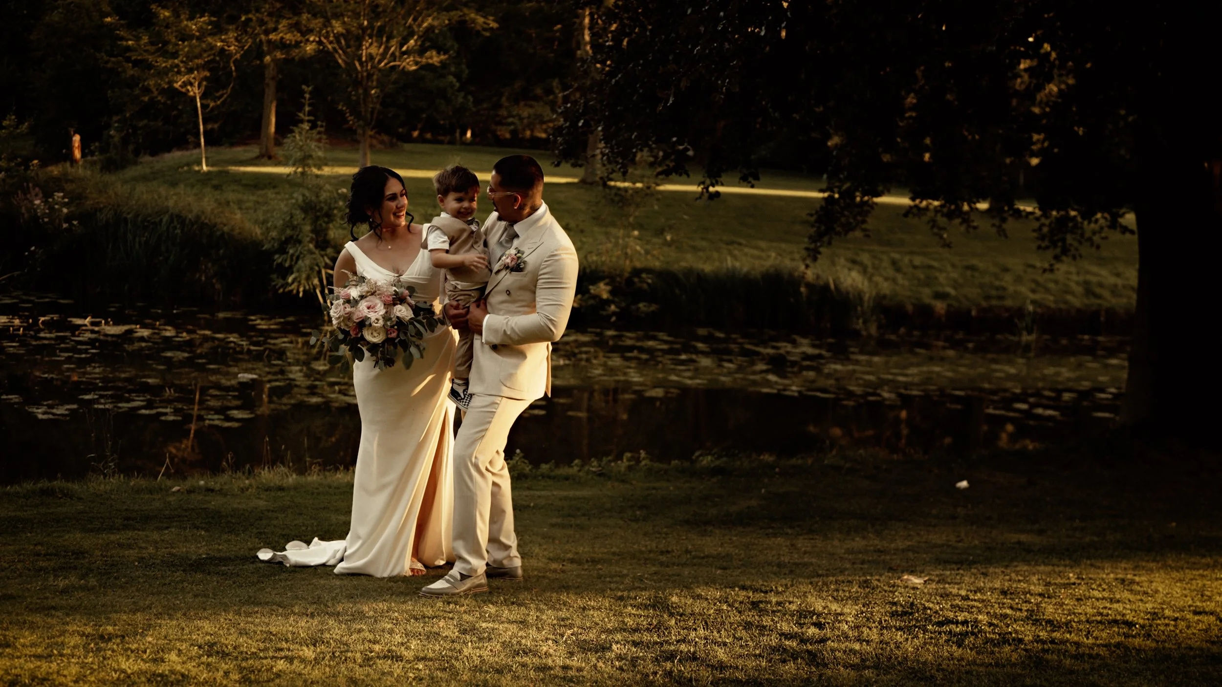 Candid guest moments by the lake at The Orangery Maidstone during a summer wedding