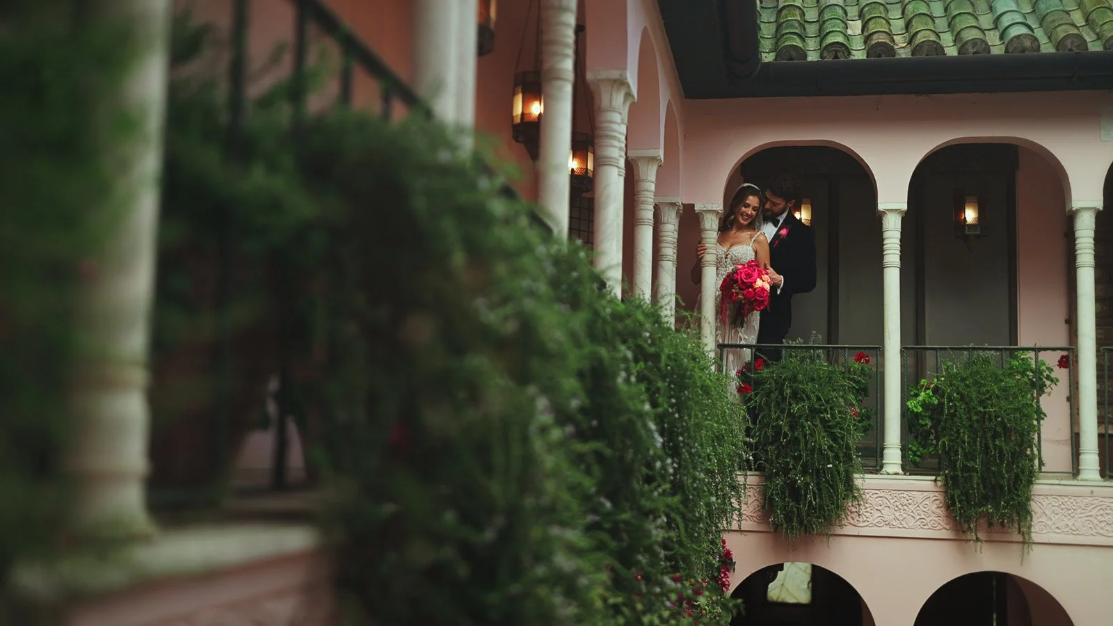 Architectural texture and floral design captured in an editorial style as a couple stand underneath an archway.