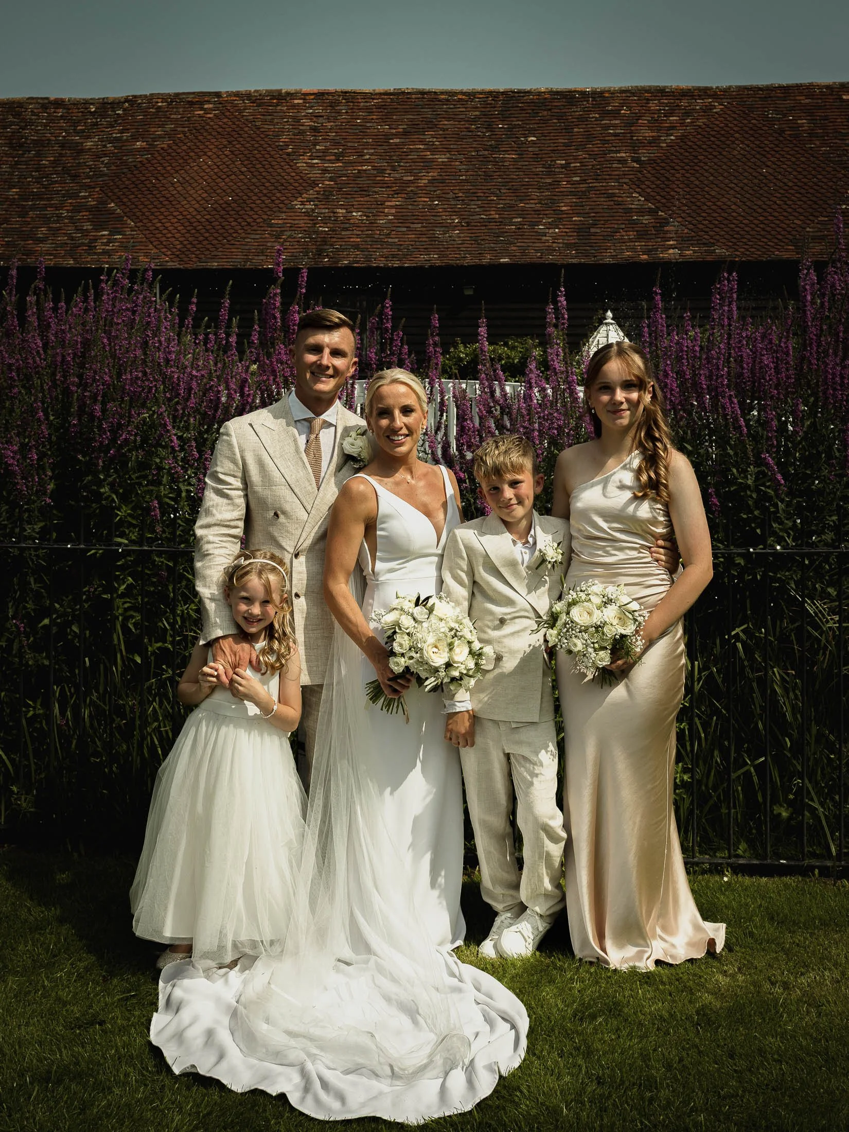 A family group portrait of the bride and groom with their children on their summer wedding day at Winters Barns.