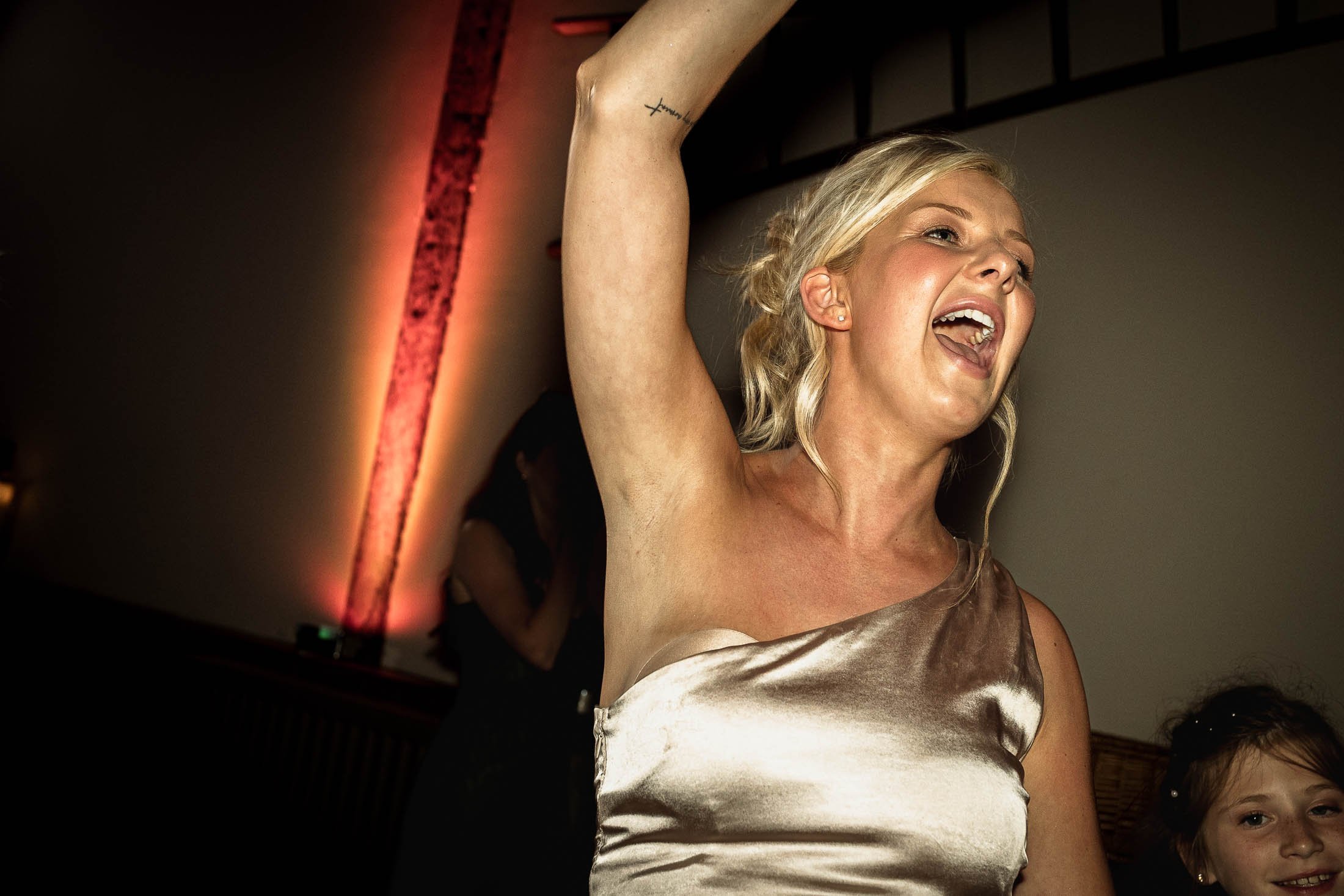 A candid dance floor moment of a bridesmaid celebrating at Winters Barns in Kent.