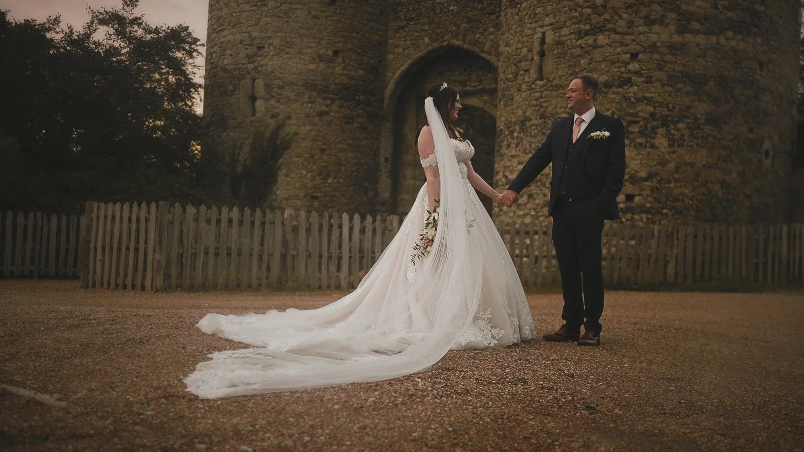 Couple portraits on the gravel driveway entrance to Cooling Castle Barn wedding venue