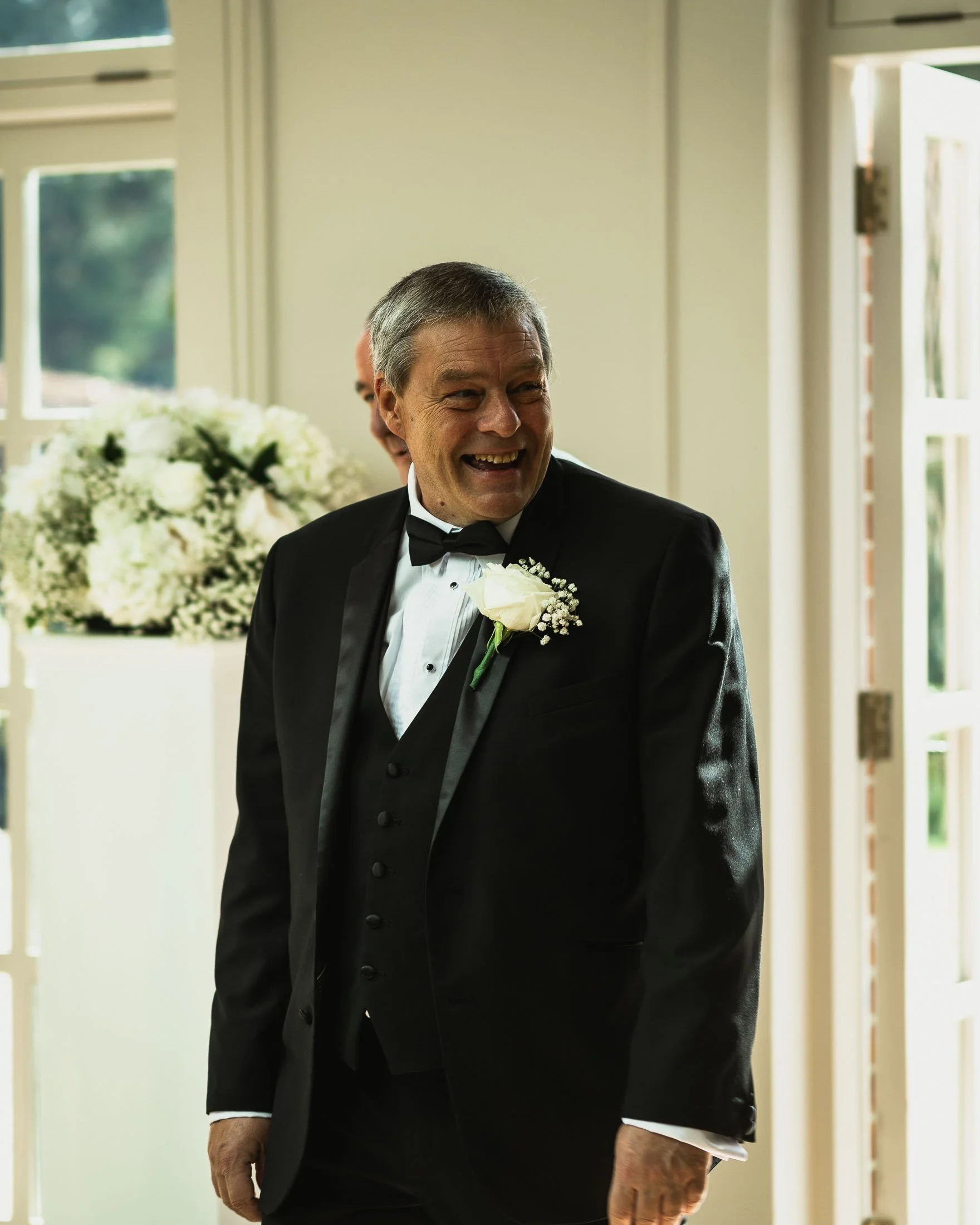A candid editorial portrait of the grooms father during an indoor wedding ceremony at The Orangery Maidstone.