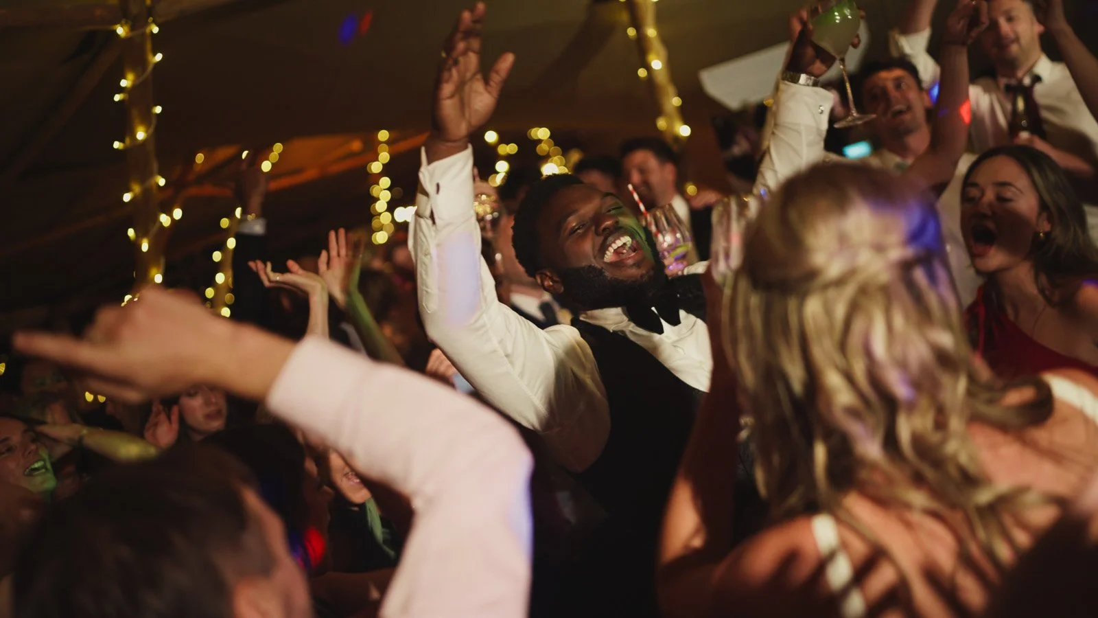 Editorial-style wedding photography from a colourful riverside celebration with bold florals and a marquee reception.